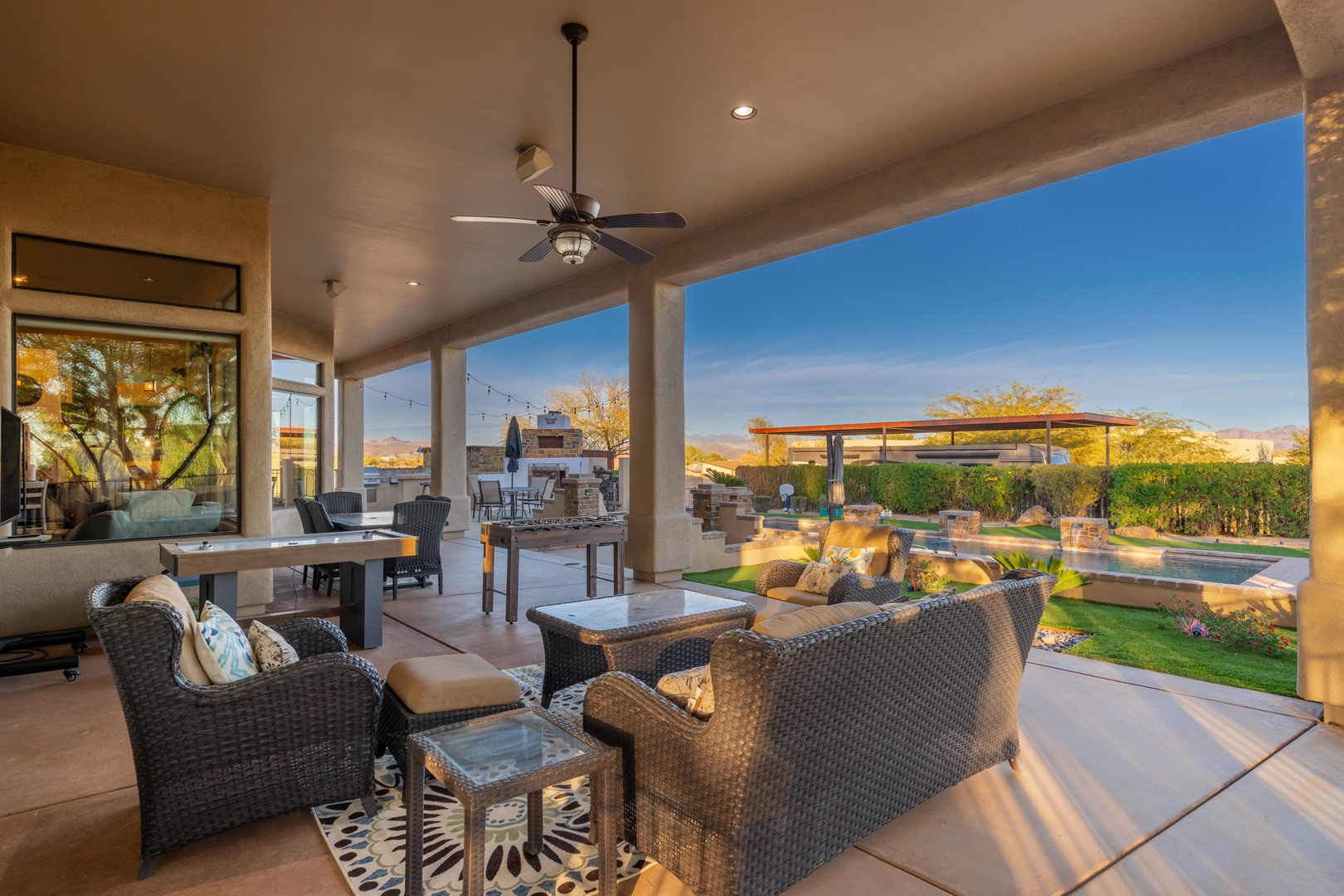 Unwind in your spacious covered patio with plush seating, overlooking the sparkling pool and stunning desert mountain views—an ideal spot for your morning coffee or evening relaxation.