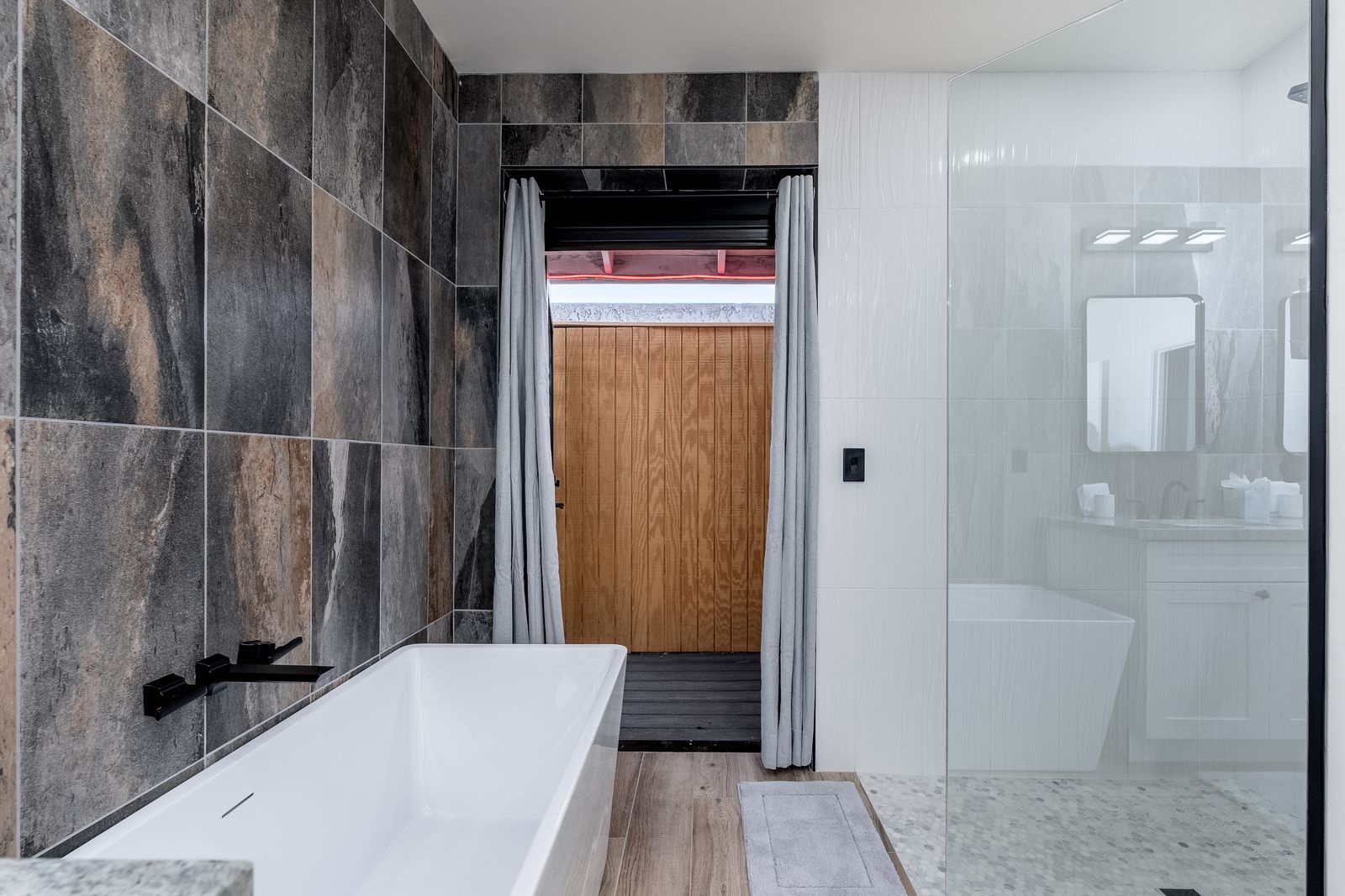 Unwind in a sleek modern bathroom featuring a deep soaking tub and expansive glass-enclosed shower—your personal spa retreat awaits.