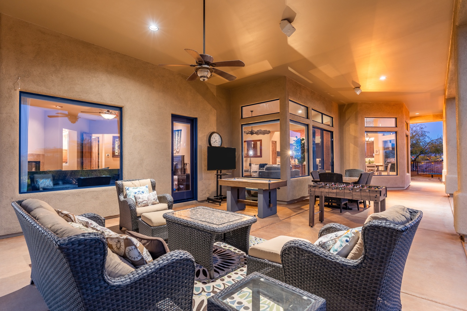Unwind under the stars in this expansive covered patio, where plush wicker seating and ambient lighting create your perfect desert evening retreat.