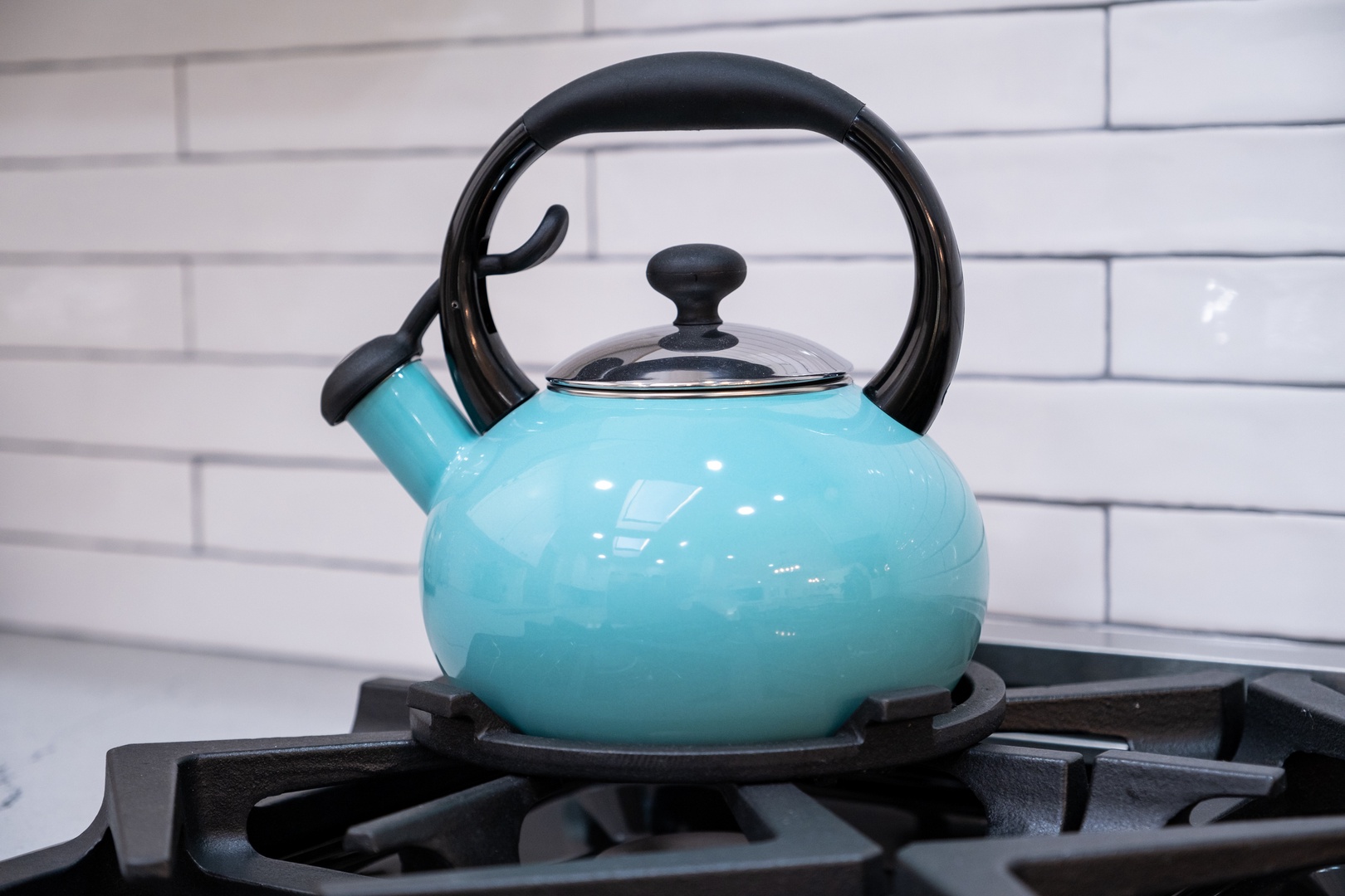 A charming turquoise kettle sits ready on the stove, perfect for brewing your morning coffee or an evening cup of tea in this thoughtfully equipped kitchen.