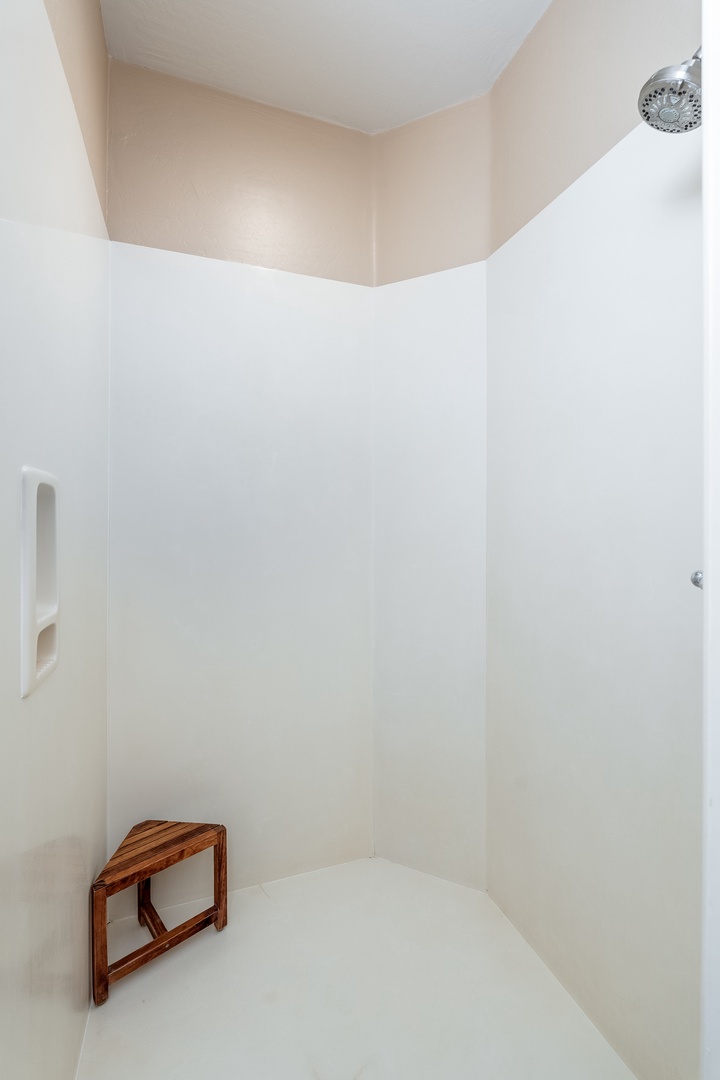 Step into your private shower with a thoughtful wooden stool for comfort—clean, spacious, and ready to refresh you after a day of adventure.