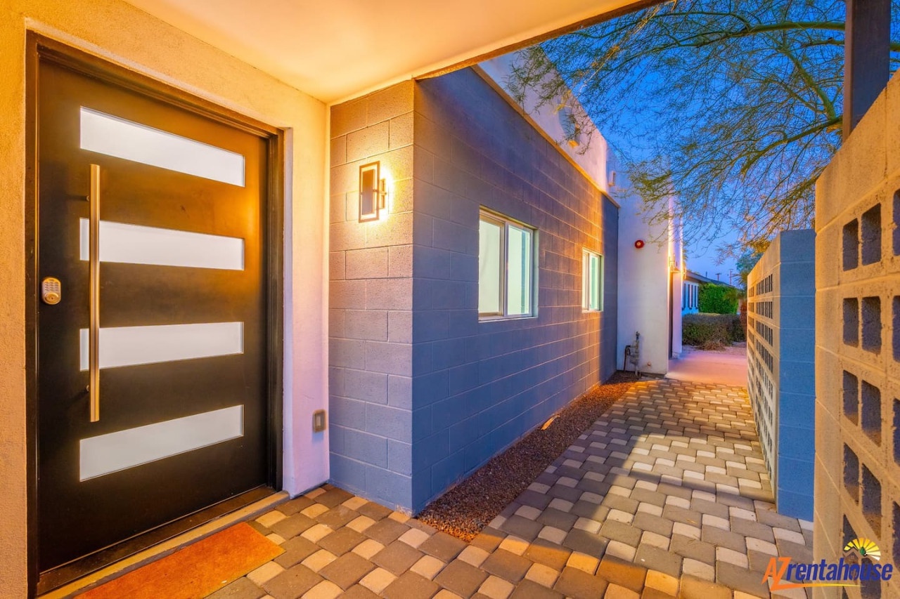 Modern entrance with sleek lines and warm lighting welcomes guests at twilight.