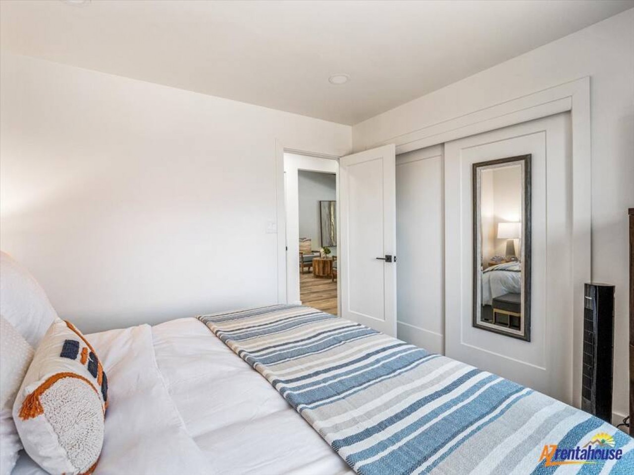 Drift off in this peaceful bedroom with crisp linens and coastal-inspired bedding that invites restful sleep.