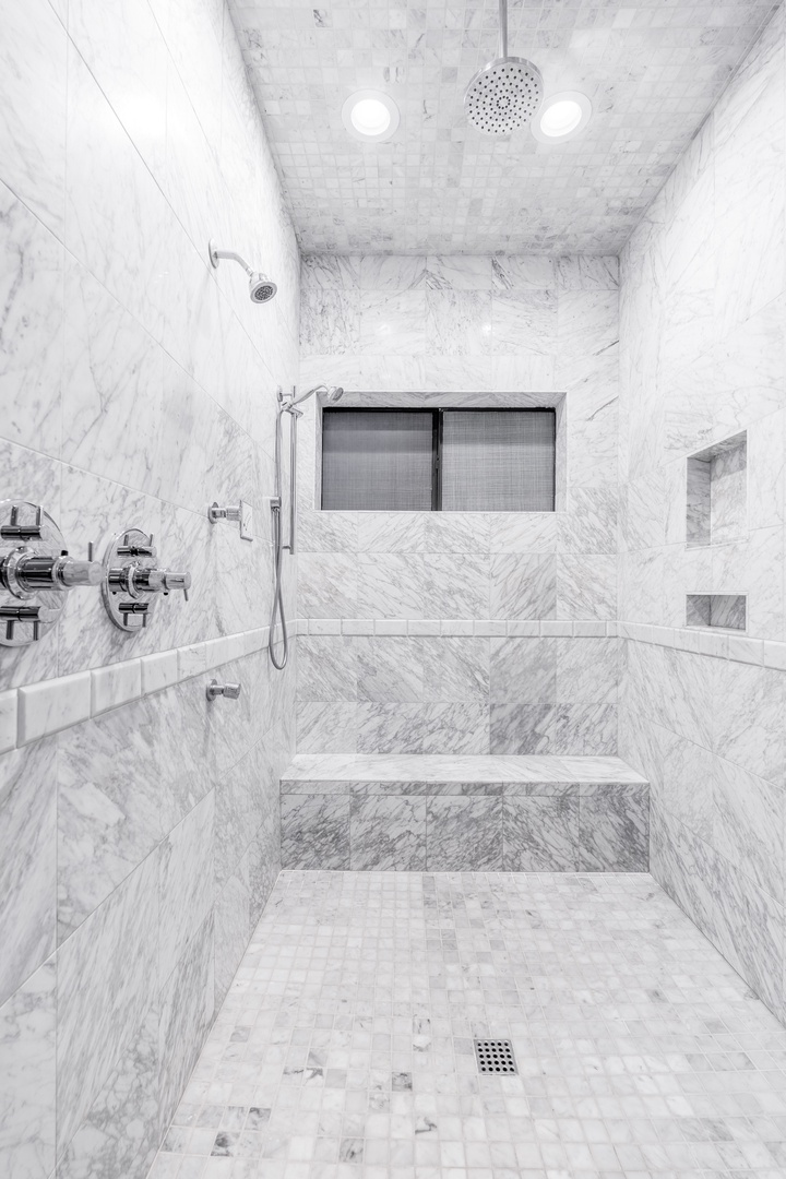 Step into your private marble sanctuary, where dual rainfall and handheld showerheads invite you to unwind after a day exploring the area.