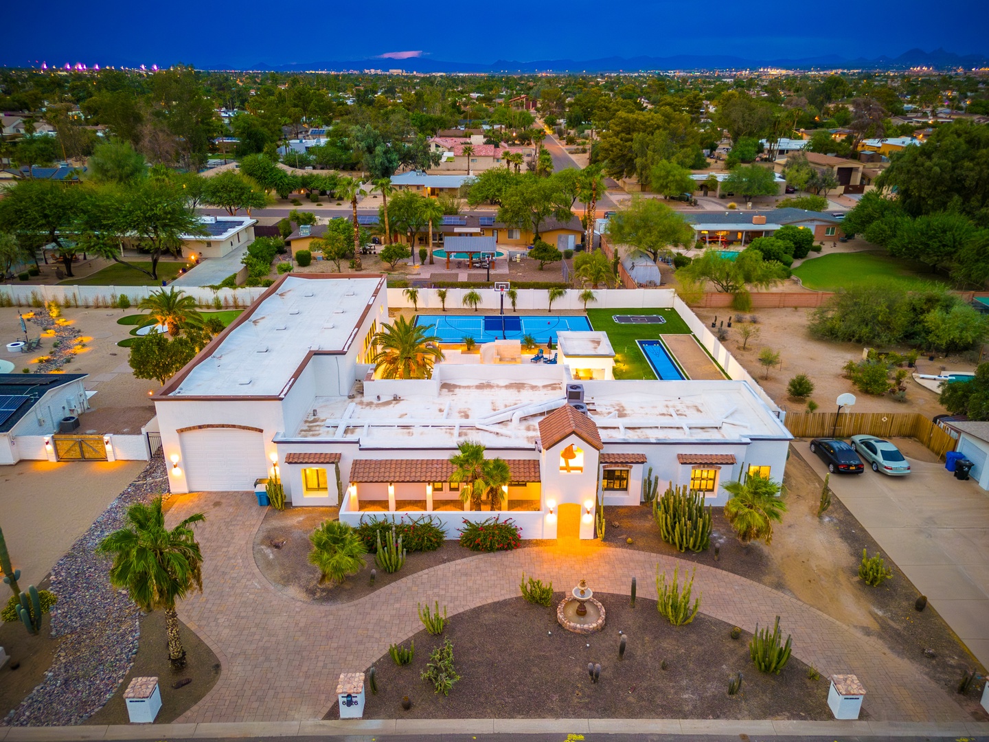 This stunning Spanish-style estate sits in a peaceful residential neighborhood, featuring a sparkling pool, sport court, and beautifully landscaped grounds with desert palms and mountain views.