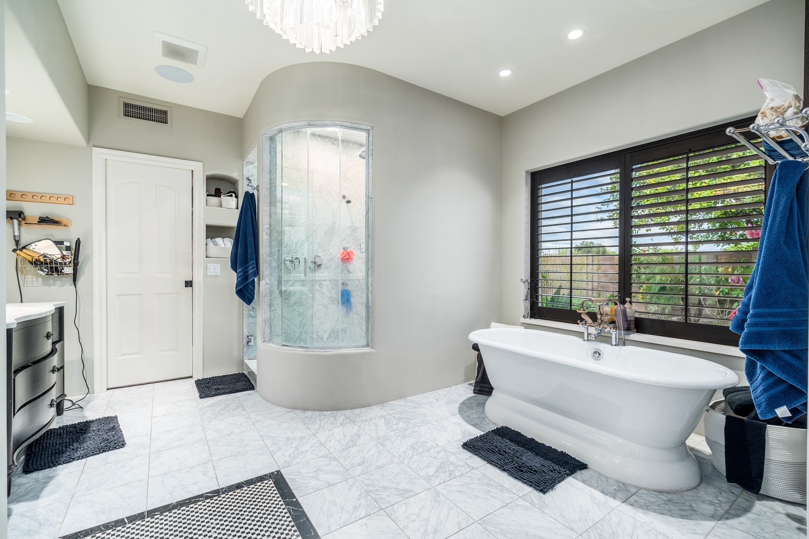 Unwind in your spa-like bathroom with a soaking tub, elegant chandelier, and spacious walk-in shower. Bright and serene, it's your private retreat after exploring the area.