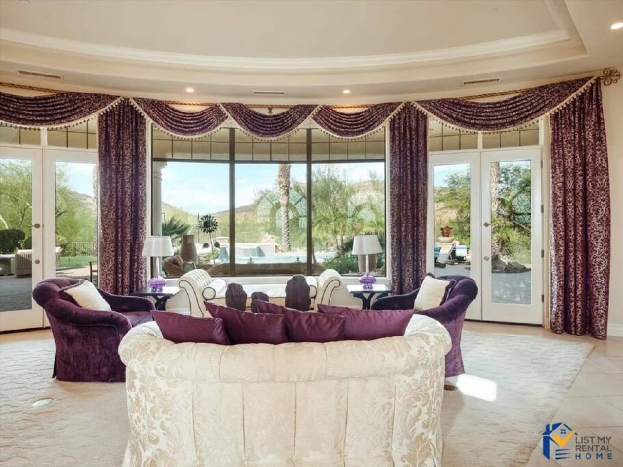Relax in your elegant living room with luxurious purple furnishings and stunning pool views through floor-to-ceiling windows.