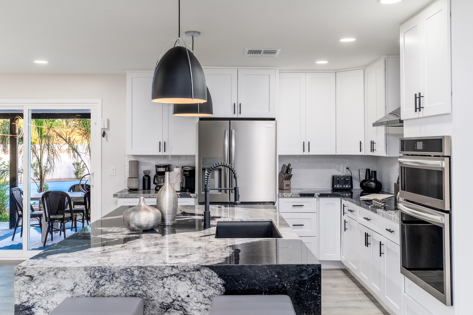 Prepare your favorite meals in this chef-inspired kitchen with sleek granite counters, stainless steel appliances, and ample cabinet space. Sunshine flows through the door to your outdoor patio.