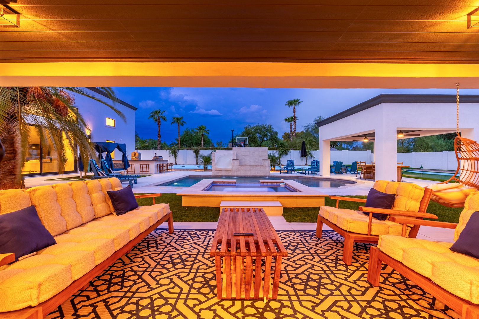 Picture yourself unwinding here as dusk falls—golden light bathes plush seating, while the pool and pavilion invite endless evenings under palm-studded skies.