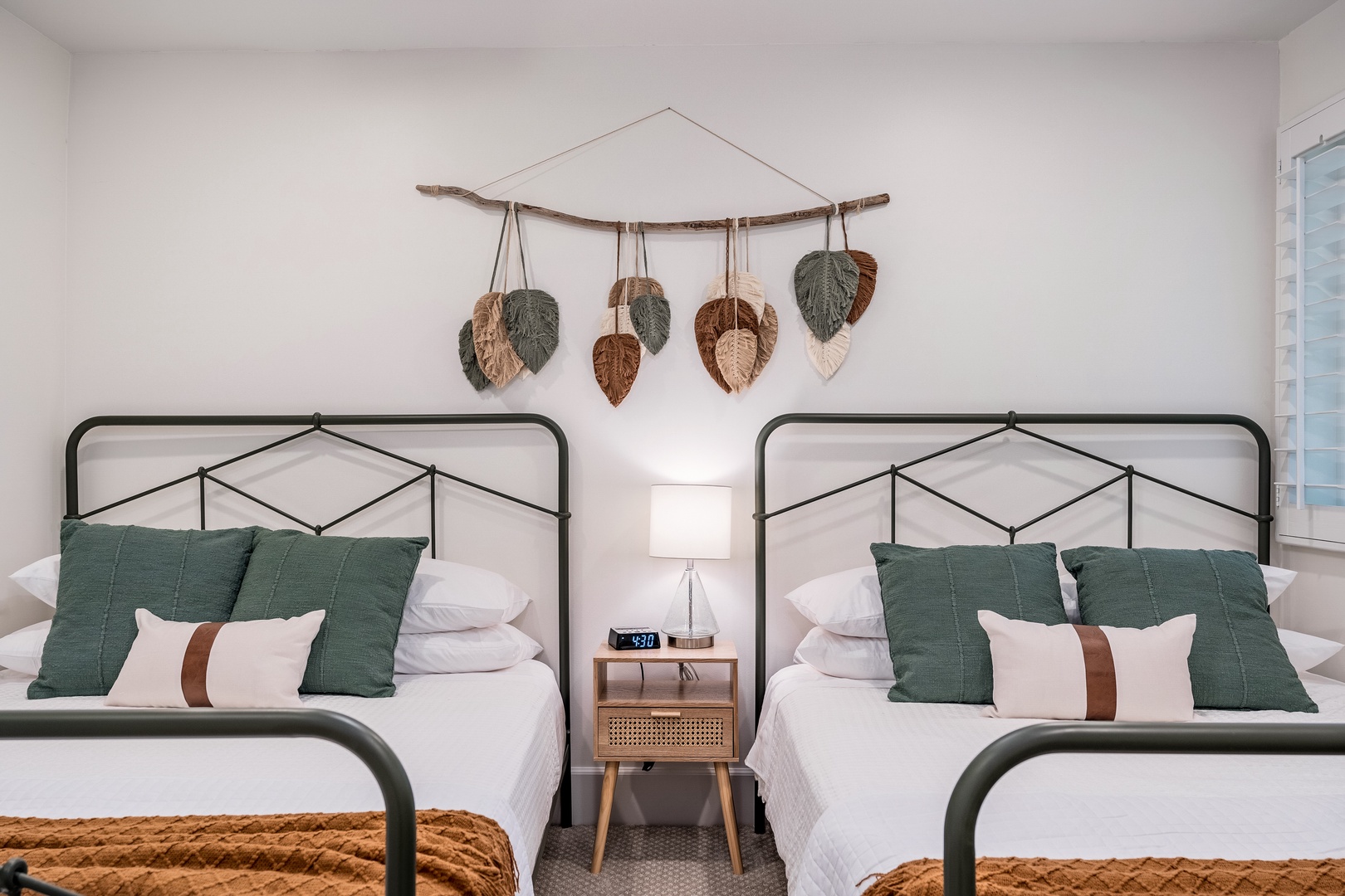 Rest easy in this serene twin bedroom where earthy textures and calming greens create your peaceful retreat. Two cozy beds with crisp linens and handcrafted wall art invite you to unwind after a day of adventure.