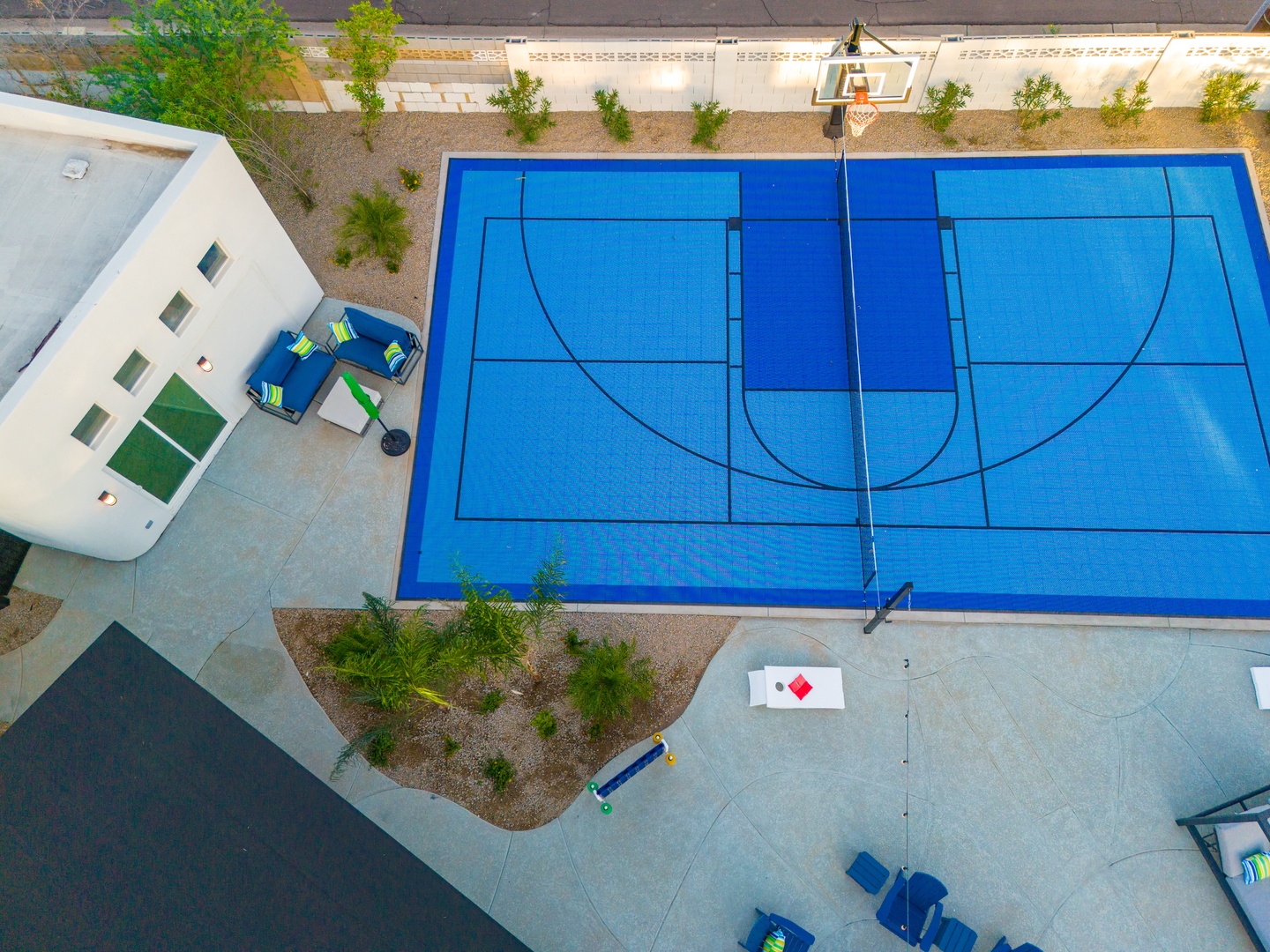 Aerial view of the property's private outdoor basketball court, complete with regulation lines and surrounded by landscaped seating areas for relaxation between games.