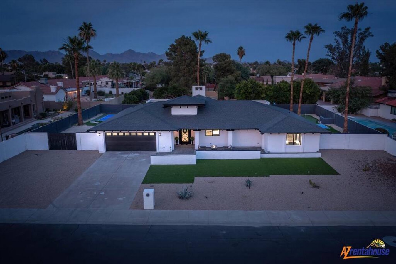 Modern desert retreat featuring clean lines and mountain backdrop in an established neighborhood with mature palm trees.