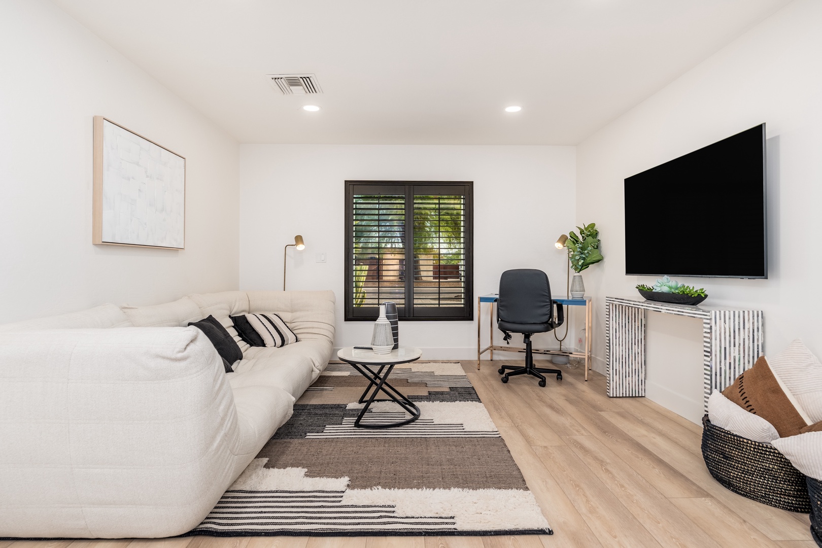 Relax in your bright, modern living space with plush seating, smart TV for entertainment, and a dedicated workspace—perfect for unwinding or staying productive during your getaway.