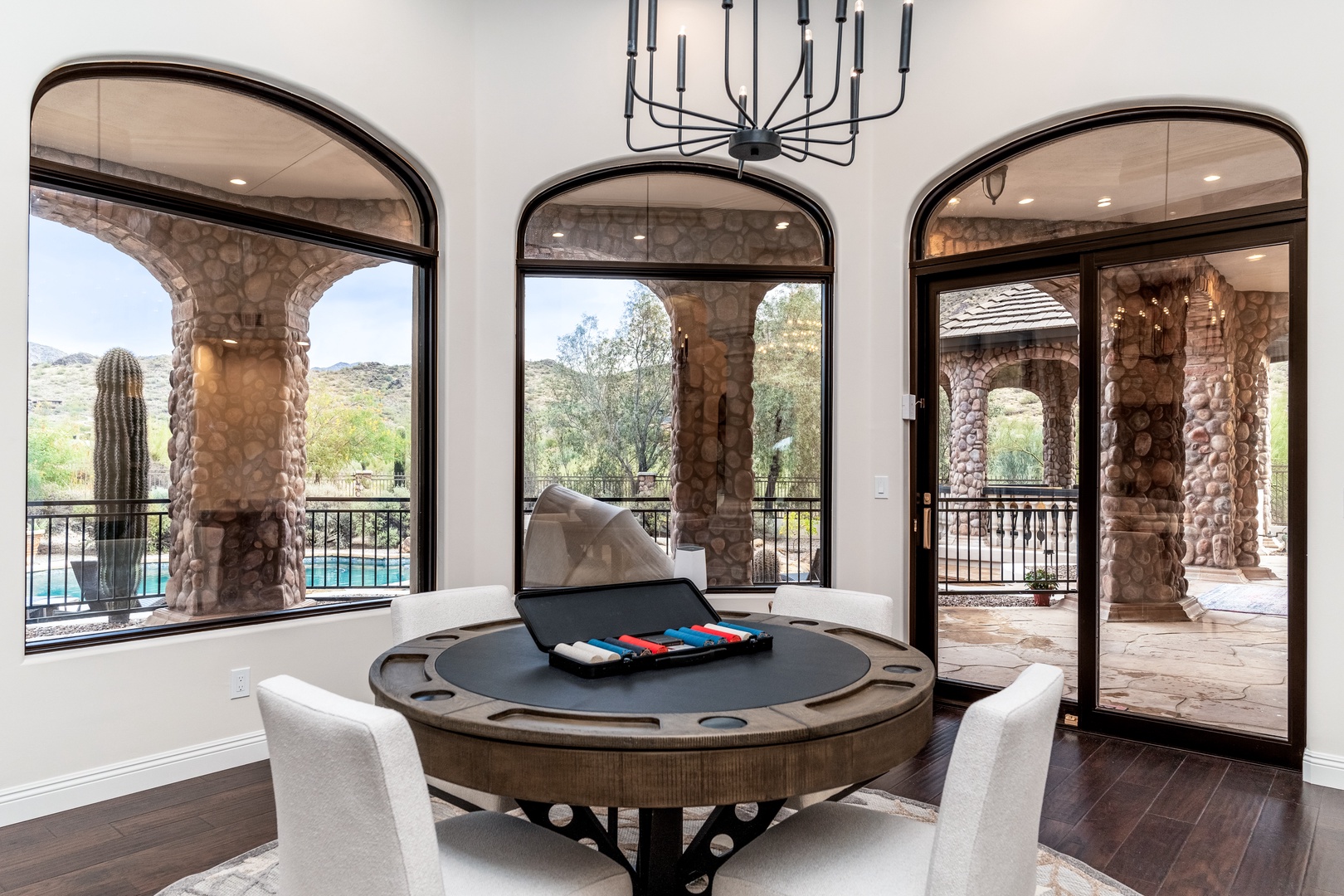 Gather around the custom poker table with sweeping desert views, then step outside to your private pool oasis framed by majestic stone columns and towering saguaro cacti.