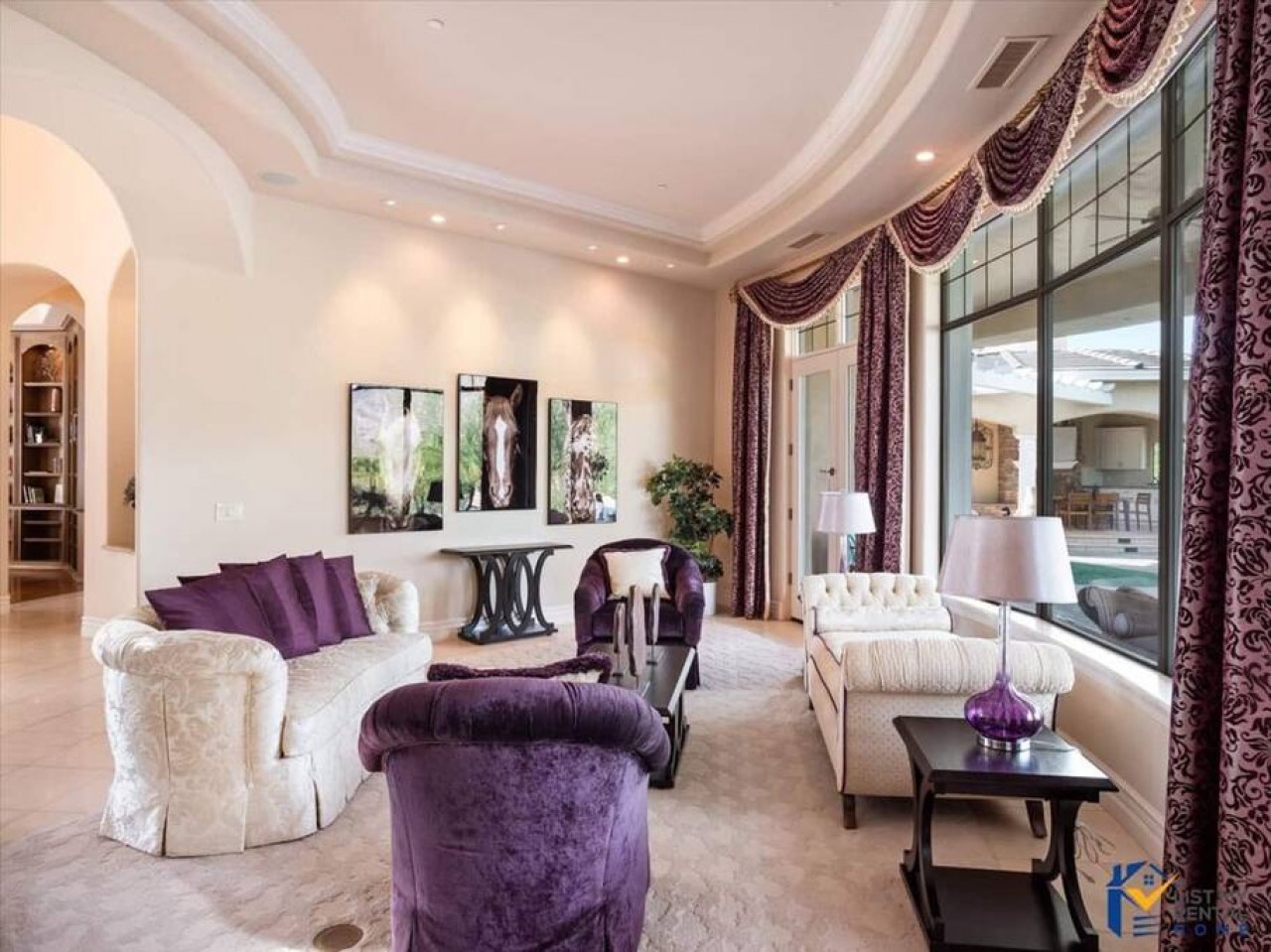 Sink into plush purple velvet seating in your elegant living room, where designer touches and marble floors create luxurious comfort for relaxing evenings.