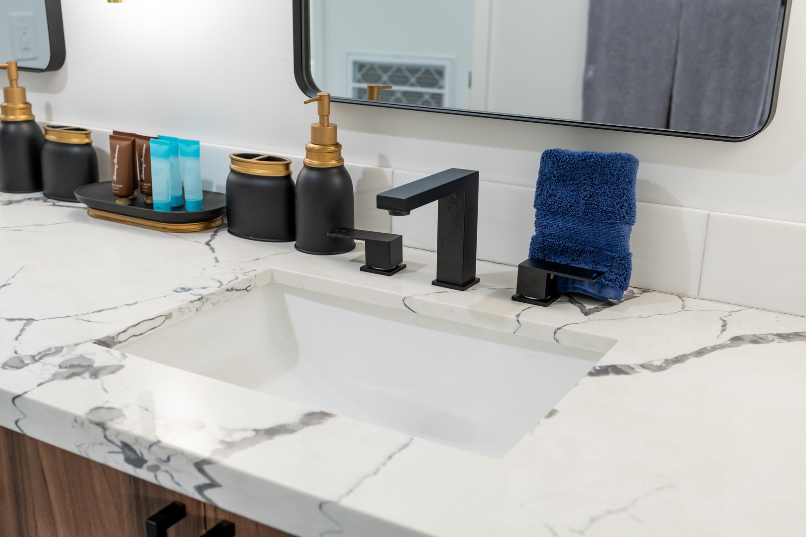 Step into your sleek, modern bathroom where elegant marble countertops and stylish black fixtures create a sophisticated retreat. Fresh towels await your arrival, ready to wrap you in comfort after a refreshing start to your day.