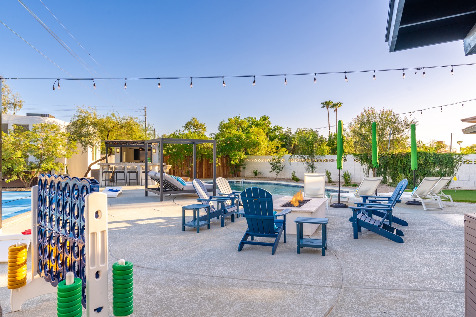 A spacious backyard retreat with a sparkling pool, fire pit seating, outdoor games, and covered lounging areas—your private oasis for sun-soaked days and starlit evenings together.