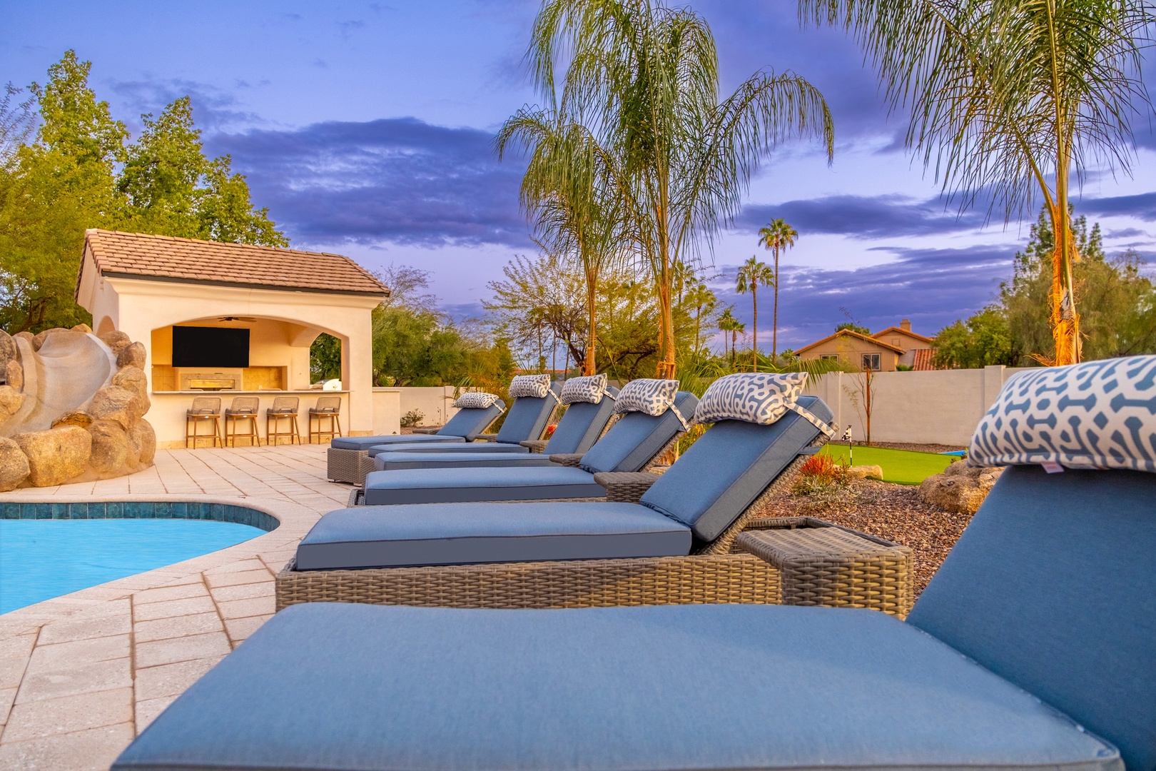 Sink into plush poolside loungers under swaying palms, with your own outdoor bar just steps away—perfect for sun-soaked afternoons and twilight refreshments.
