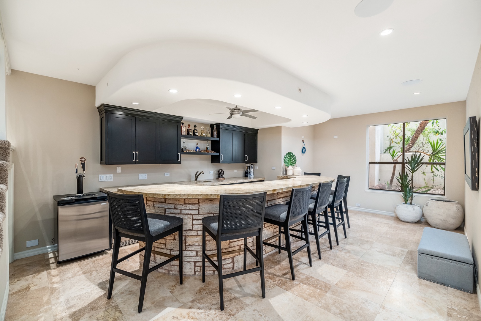 Gather around your private bar with elegant stone counters and modern black cabinetry, where casual meals and evening drinks feel effortlessly special.