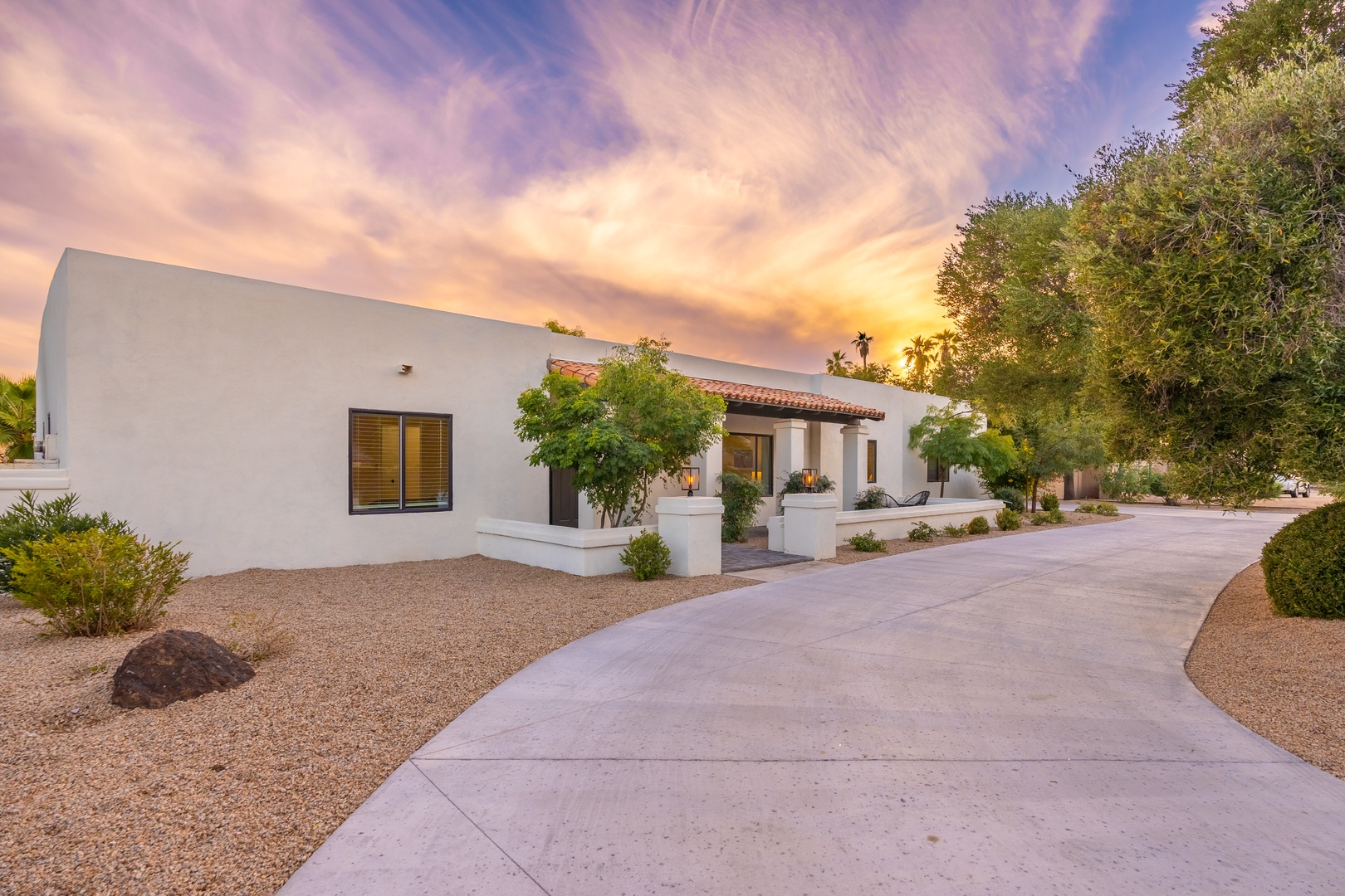 Arrive at your desert retreat where modern architecture meets stunning southwestern sunsets. The clean-lined exterior and lush desert landscaping set the perfect stage for your getaway.