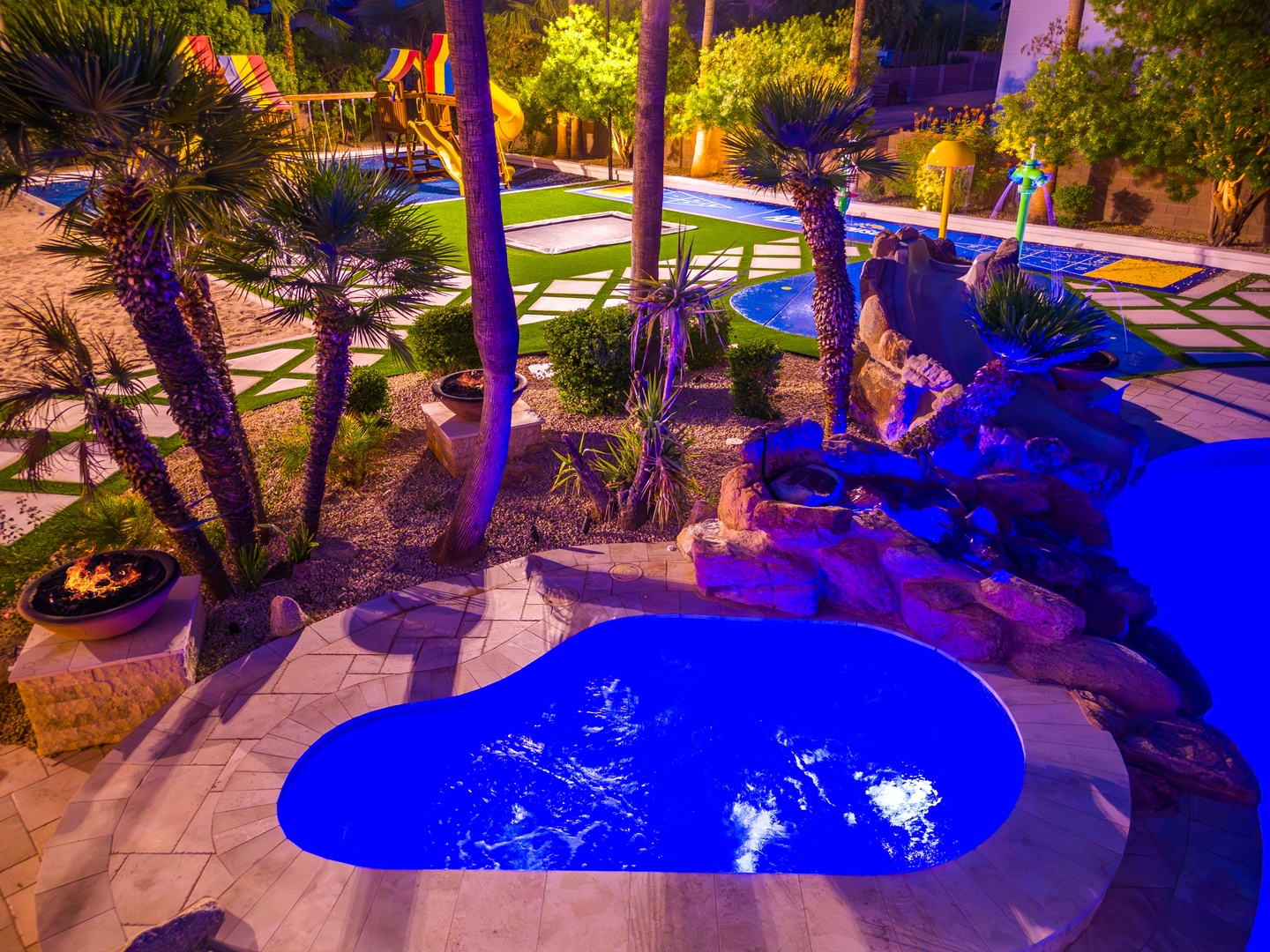 A stunning resort oasis at twilight, featuring illuminated pools, palm-lined pathways, and vibrant landscaping creating a magical evening ambiance for relaxation and leisure.