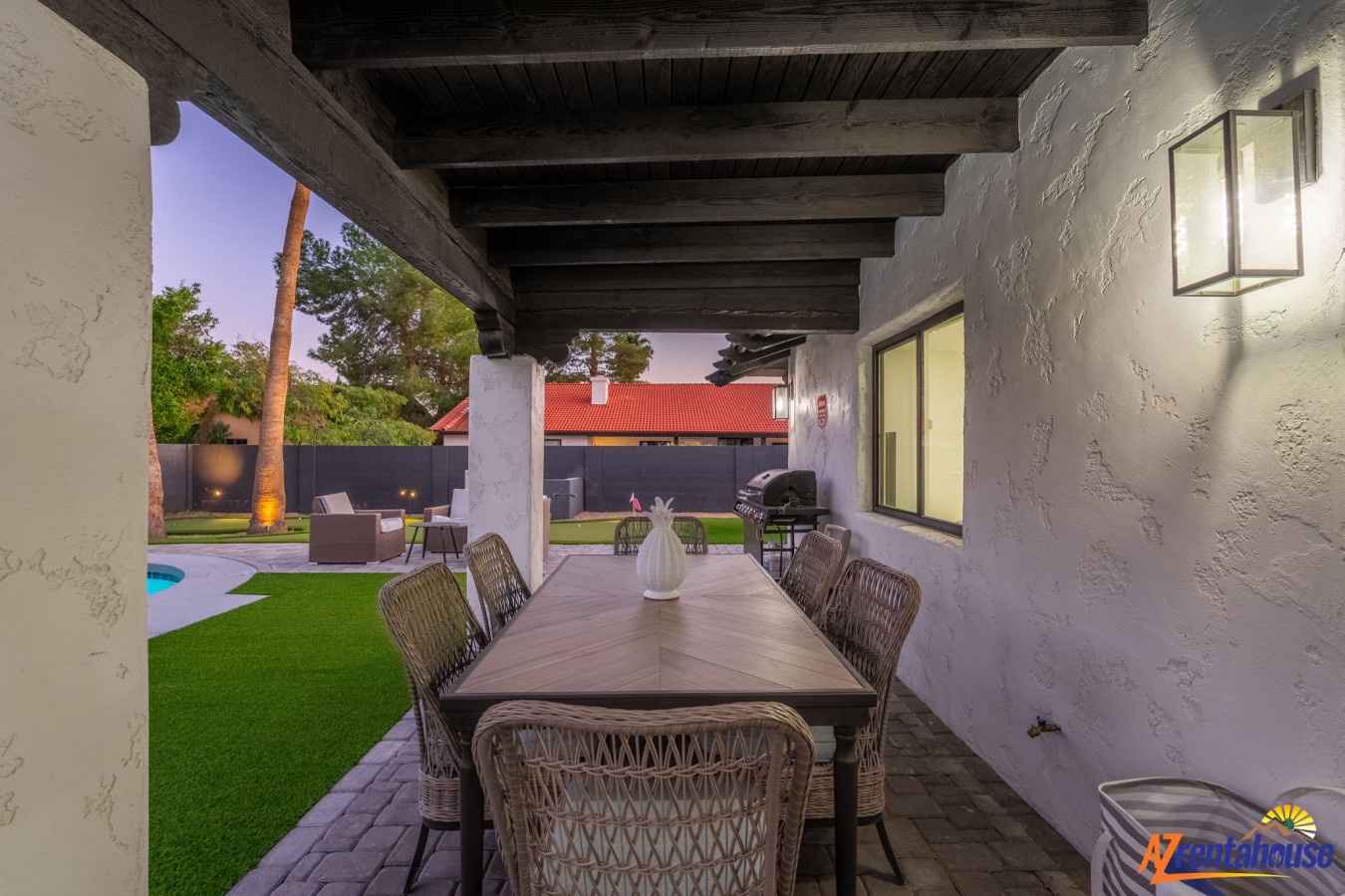 Unwind at your covered dining area with twilight views of the manicured backyard and sparkling pool, perfect for evening meals.