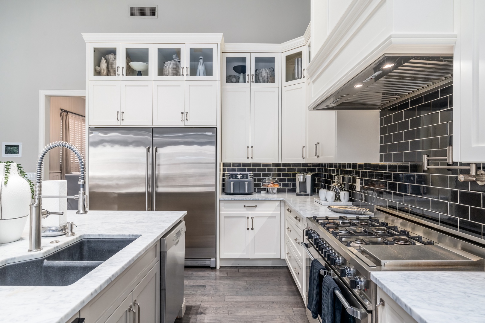 Cook your favorite meals in this elegant chef's kitchen with stainless steel appliances, gas range, sleek subway tile backsplash, and ample counter space for meal prep.