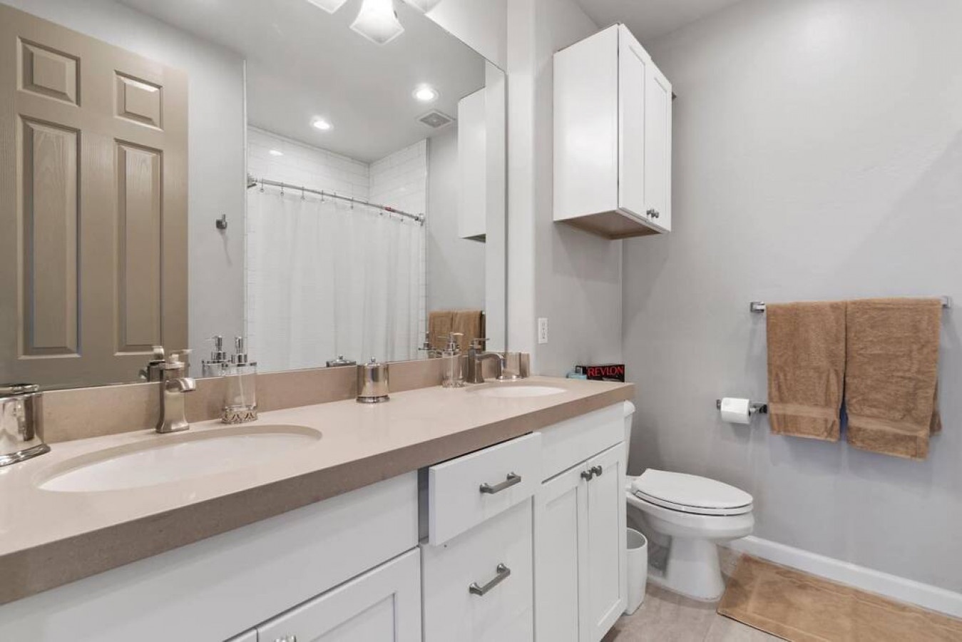Your modern bathroom features dual vanities, ample storage, and fresh towels ready for your stay.