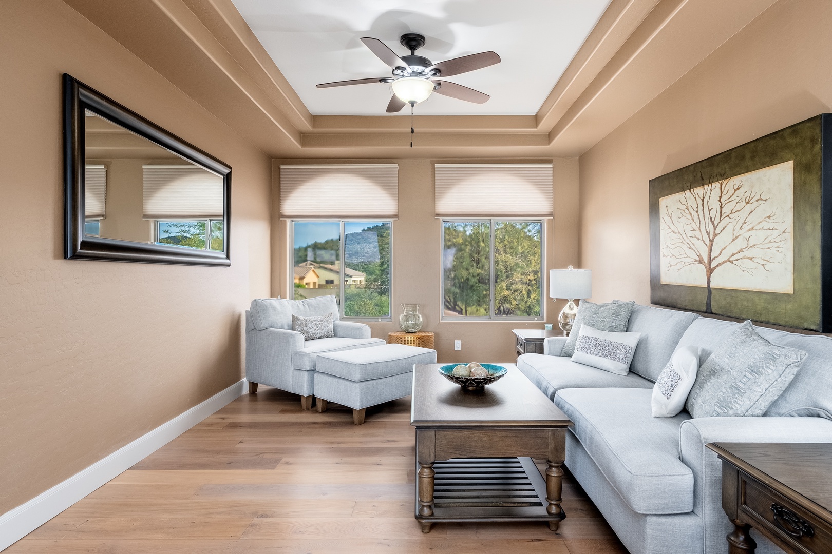 Sink into plush seating beneath the tray ceiling and enjoy natural light from three large windows framing peaceful neighborhood views. Your perfect spot to unwind and relax.