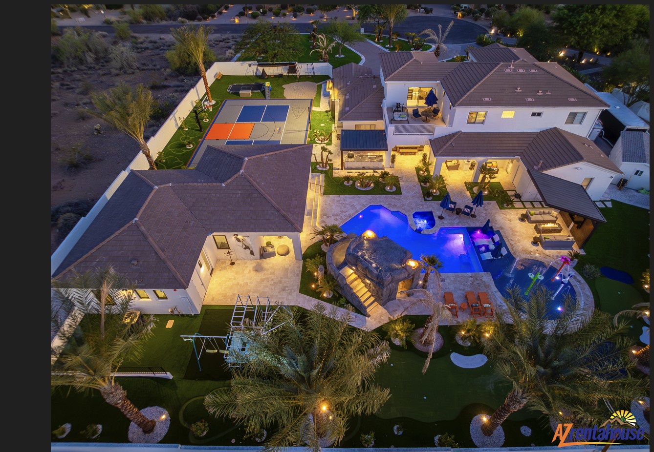 Stunning aerial view of a luxury estate featuring a spectacular pool, sports courts, and multiple outdoor entertainment areas set within lush landscaping.