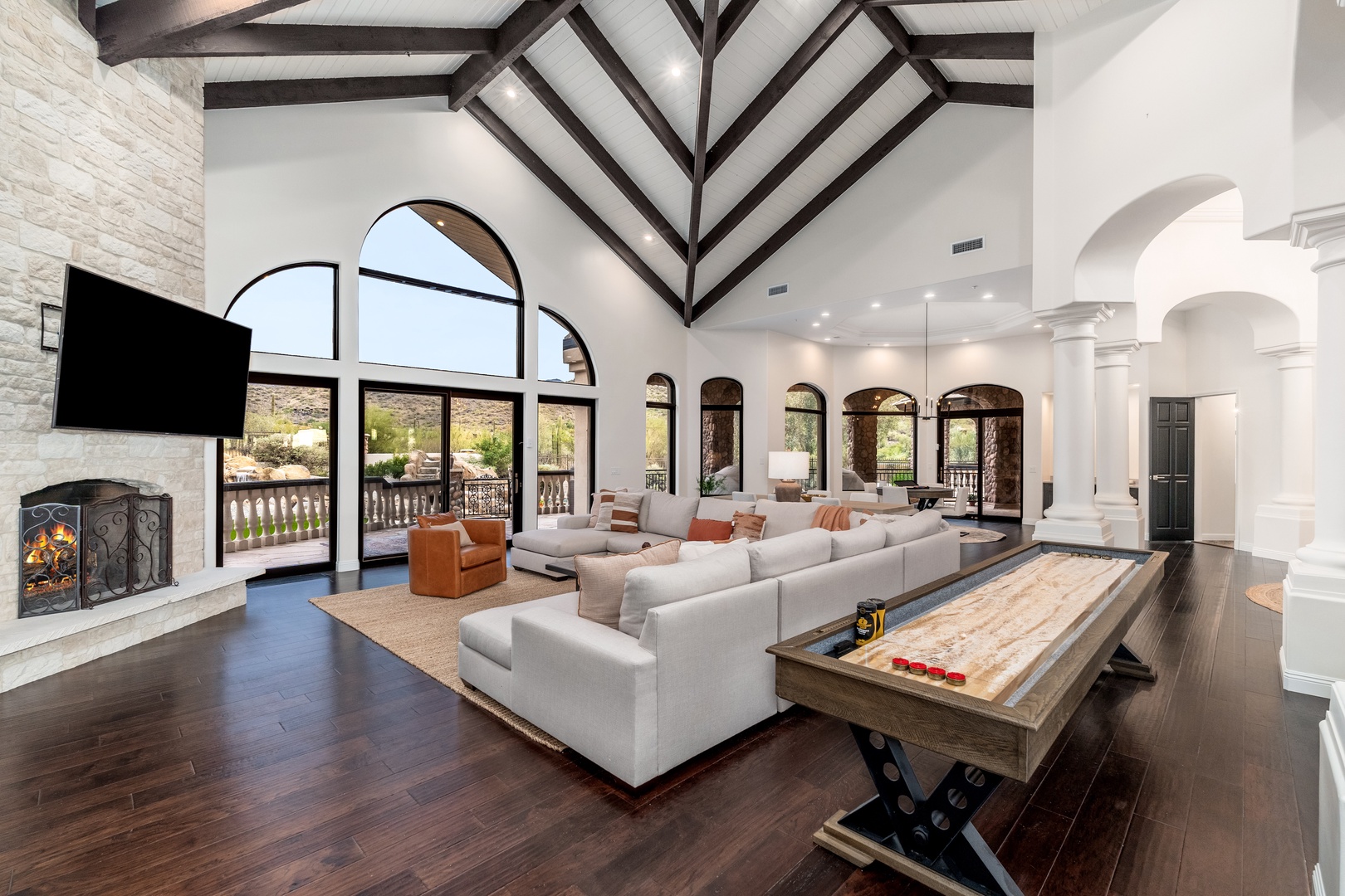 Relax in your stunning living room with soaring ceilings, modern fireplace, mountain views, and a game table—perfect for making memories with loved ones.