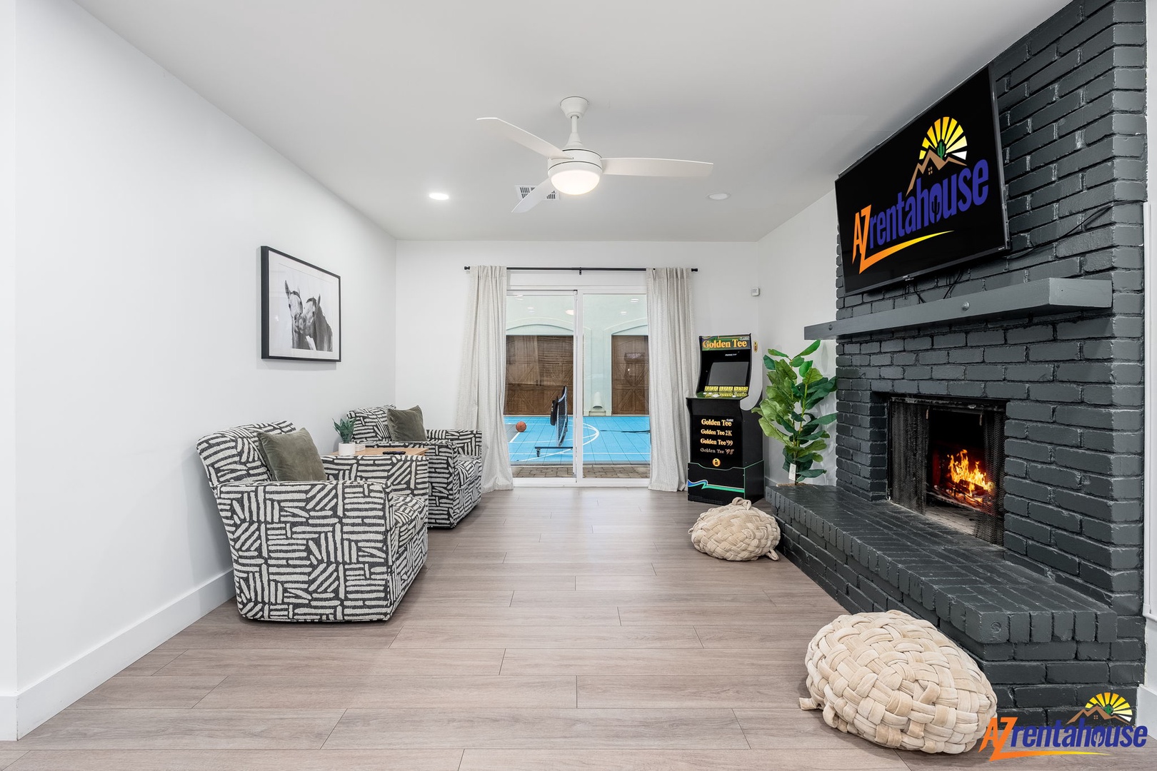 Relax in your modern living room featuring a cozy fireplace and sleek patterned sofa, with patio pool views just steps away.