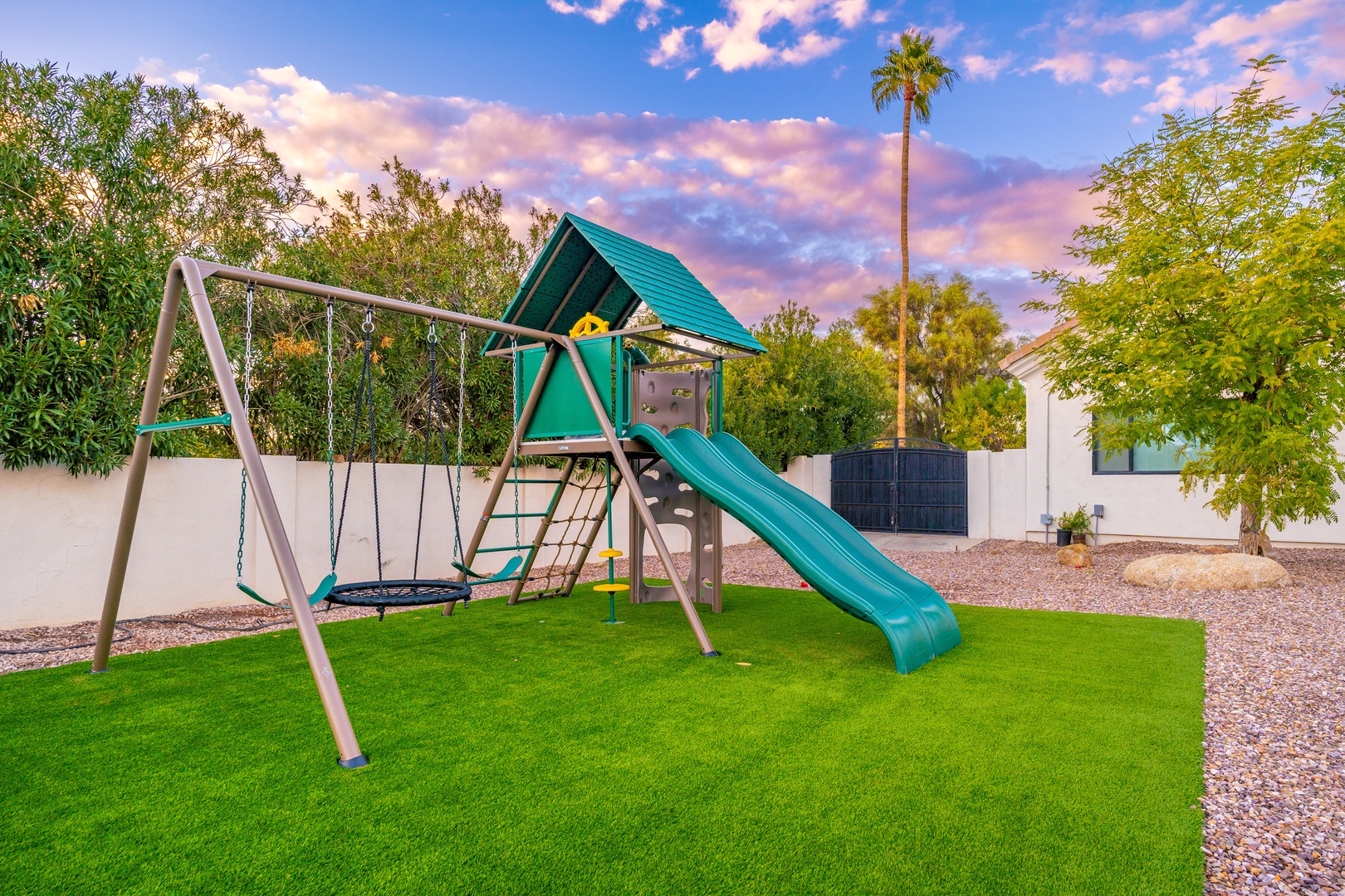 A private play area set beneath a painted desert sky, perfect for families traveling with children who need safe outdoor space to play.