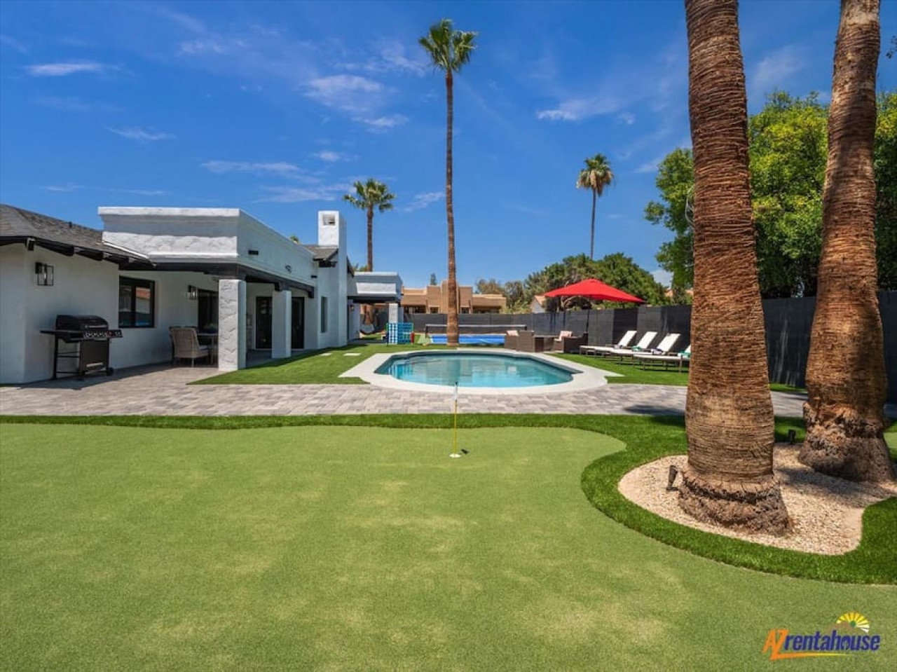 Step into your private oasis featuring a sparkling pool, putting green, and palm-lined backyard perfect for endless relaxation and fun.