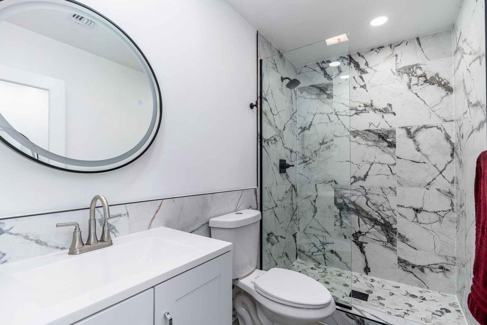 Step into a spa-like retreat with elegant marble walls, a sleek glass-enclosed shower, and modern fixtures that make your daily routine feel luxurious.