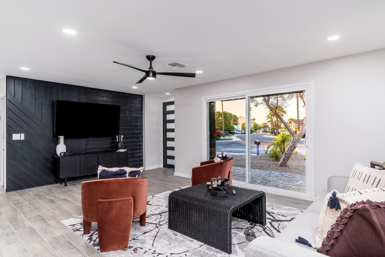 Unwind in this bright, modern living space with sleek black accents and a large flat-screen TV. Slide open the glass doors to seamlessly blend indoor comfort with your private outdoor area.