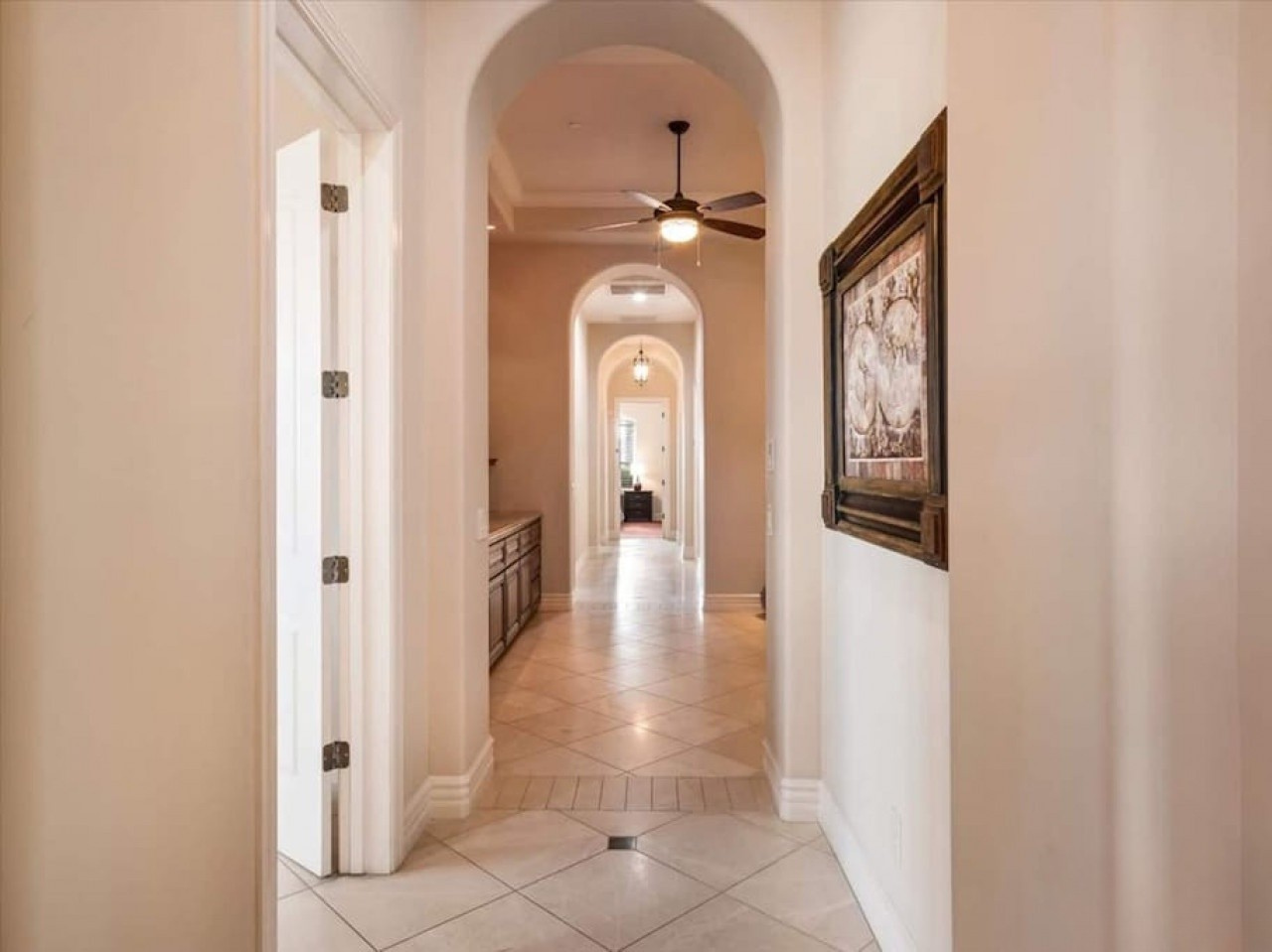 This inviting hallway welcomes you with elegant arched ceilings and warm tile floors, connecting you to the home's comfortable spaces and creating a gracious sense of arrival.