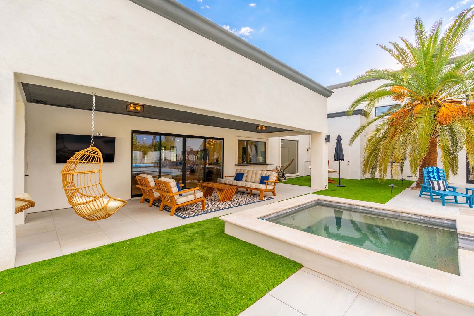 Modern luxury awaits you in this sun-drenched courtyard, complete with a private pool, cozy swing chair, and vibrant lounge seating under swaying palms—your perfect retreat.