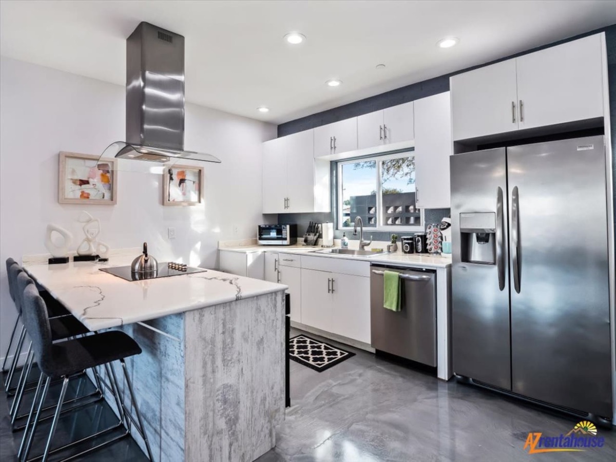 Cook your favorite meals in this stunning modern kitchen featuring stainless steel appliances, marble countertops, and a breakfast bar for casual dining.