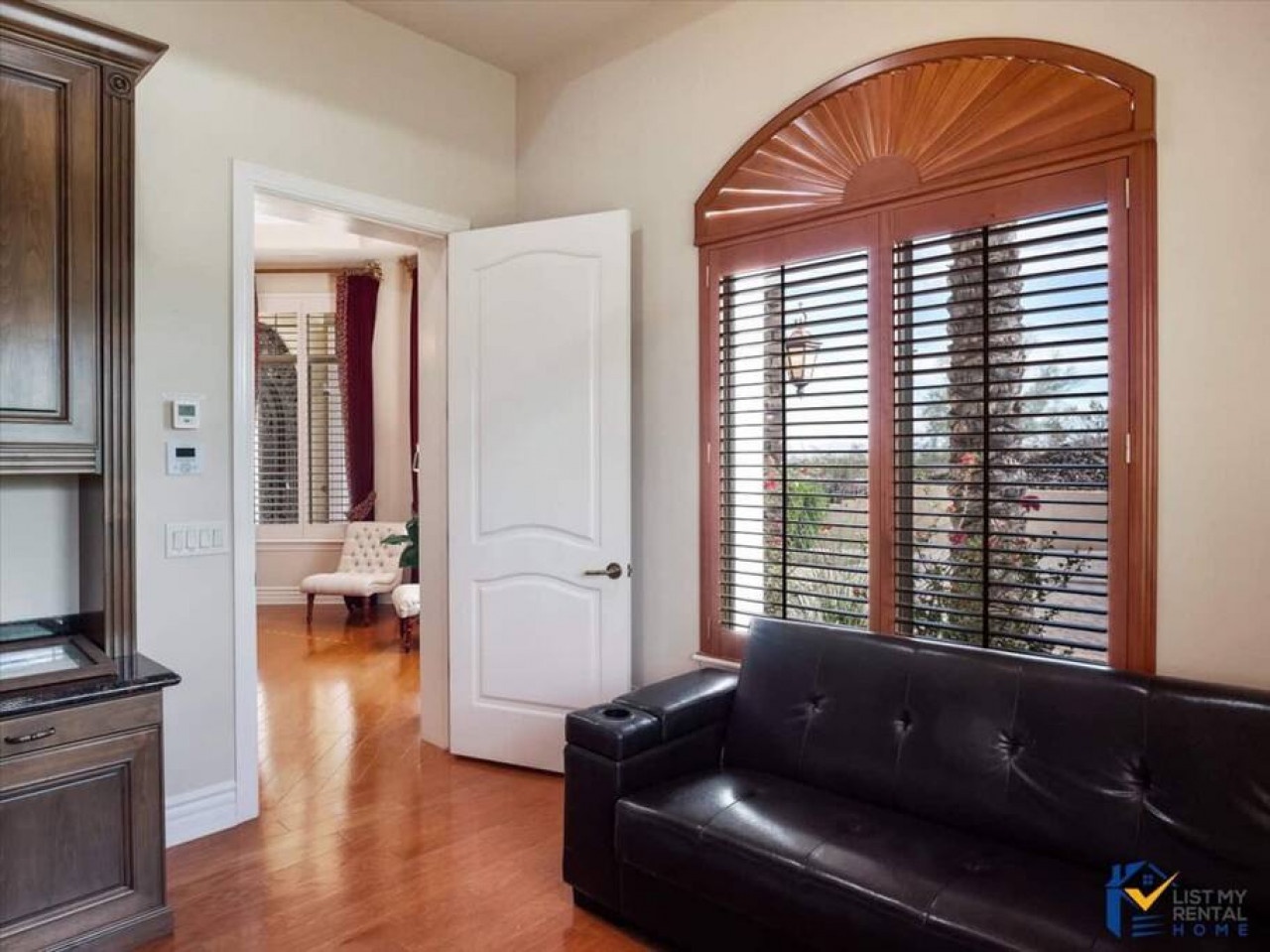 Sink into rich leather seating while sunlight filters through elegant shutters, creating your perfect reading nook.