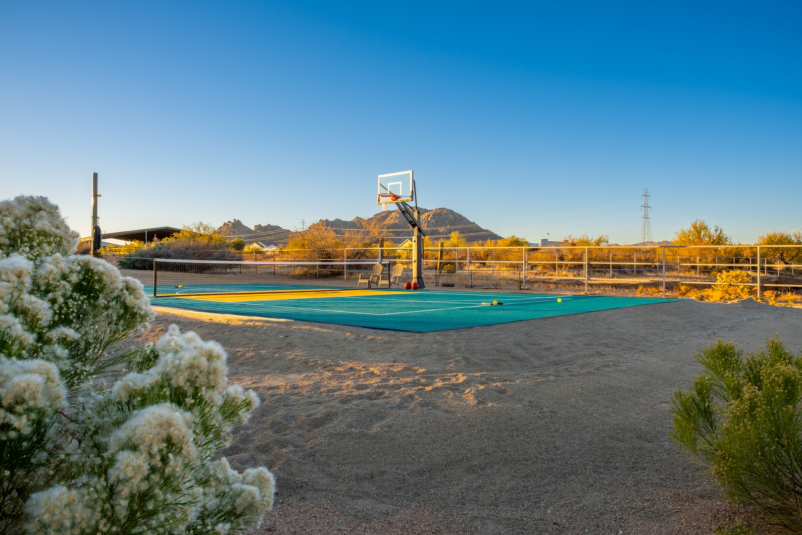 This property features an outdoor sport court with basketball hoop set against scenic mountain views, offering recreation in a peaceful desert landscape setting.