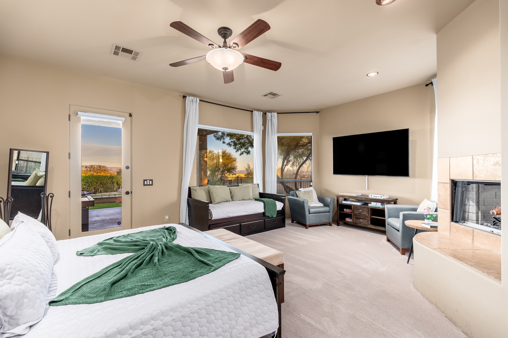 Unwind in your spacious master suite with a cozy daybed, plush seating, and views of golden sunsets. The ceiling fan keeps you cool while your private patio invites morning coffee or evening stargazing.
