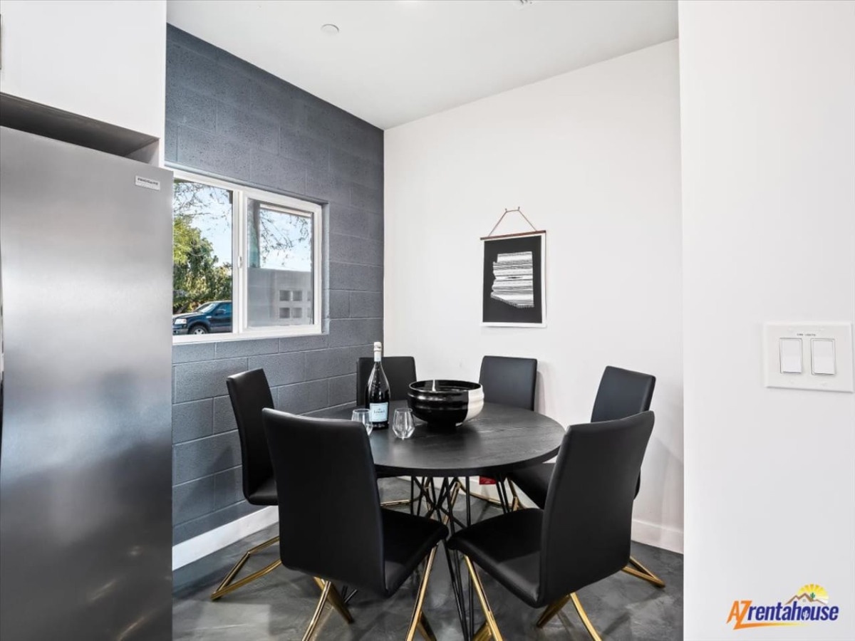 Gather around this sleek dining table for memorable meals, surrounded by modern design and natural light streaming through the window.