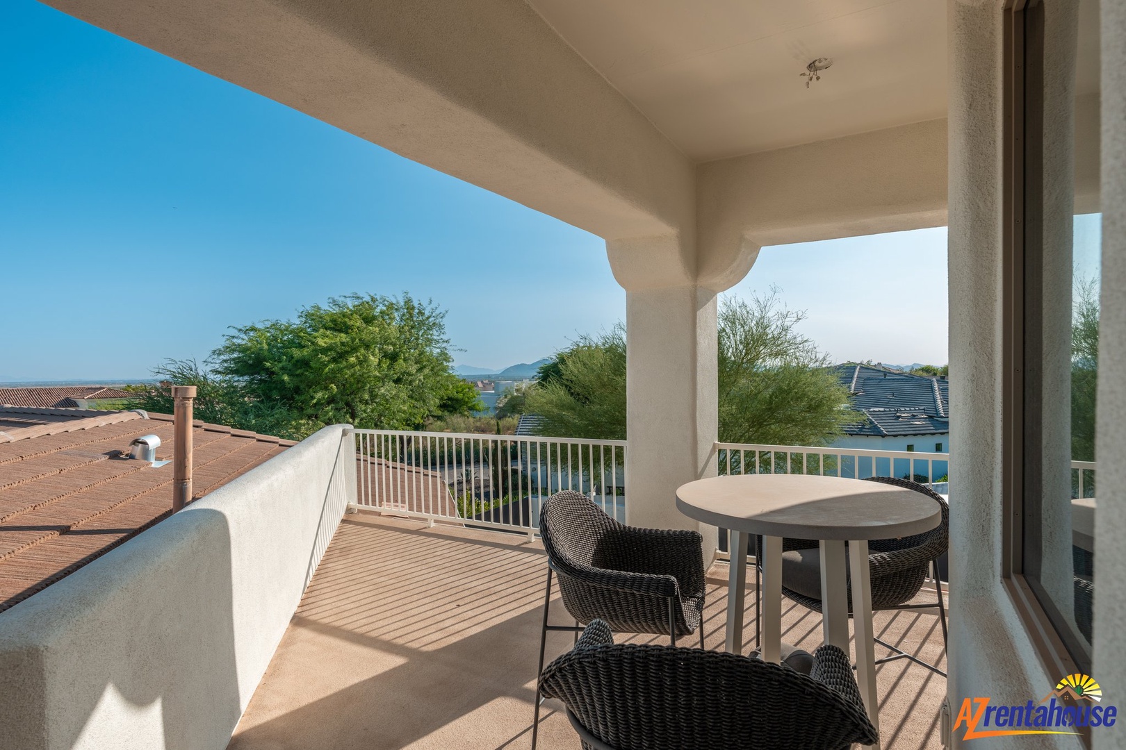 Your private balcony beckons with comfortable seating and stunning views over treetops and neighboring rooftops, perfect for morning coffee or evening relaxation.