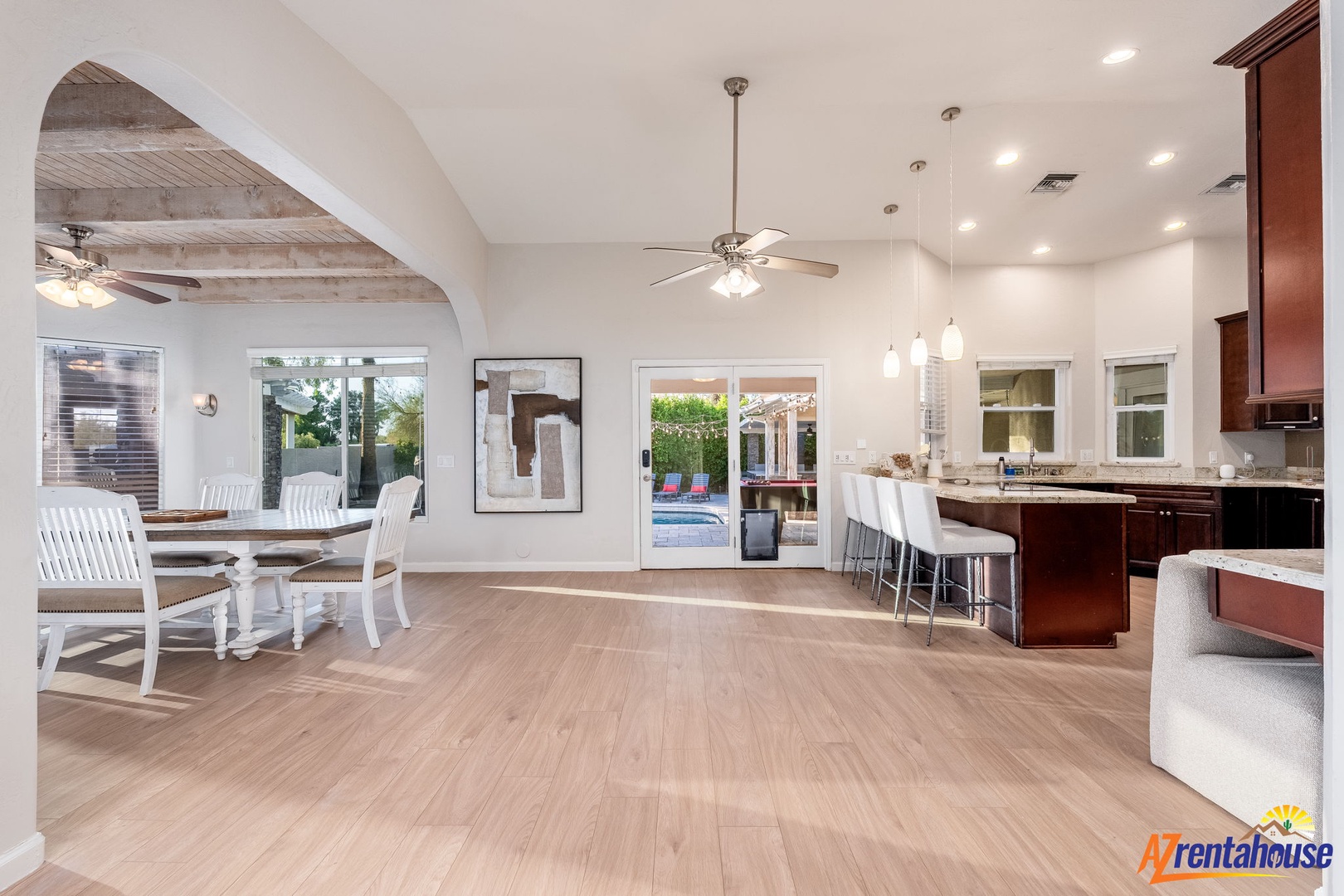 Your open-concept living space flows beautifully from dining to kitchen, with vaulted ceilings and abundant natural light creating an airy, welcoming retreat for gathering and relaxation.