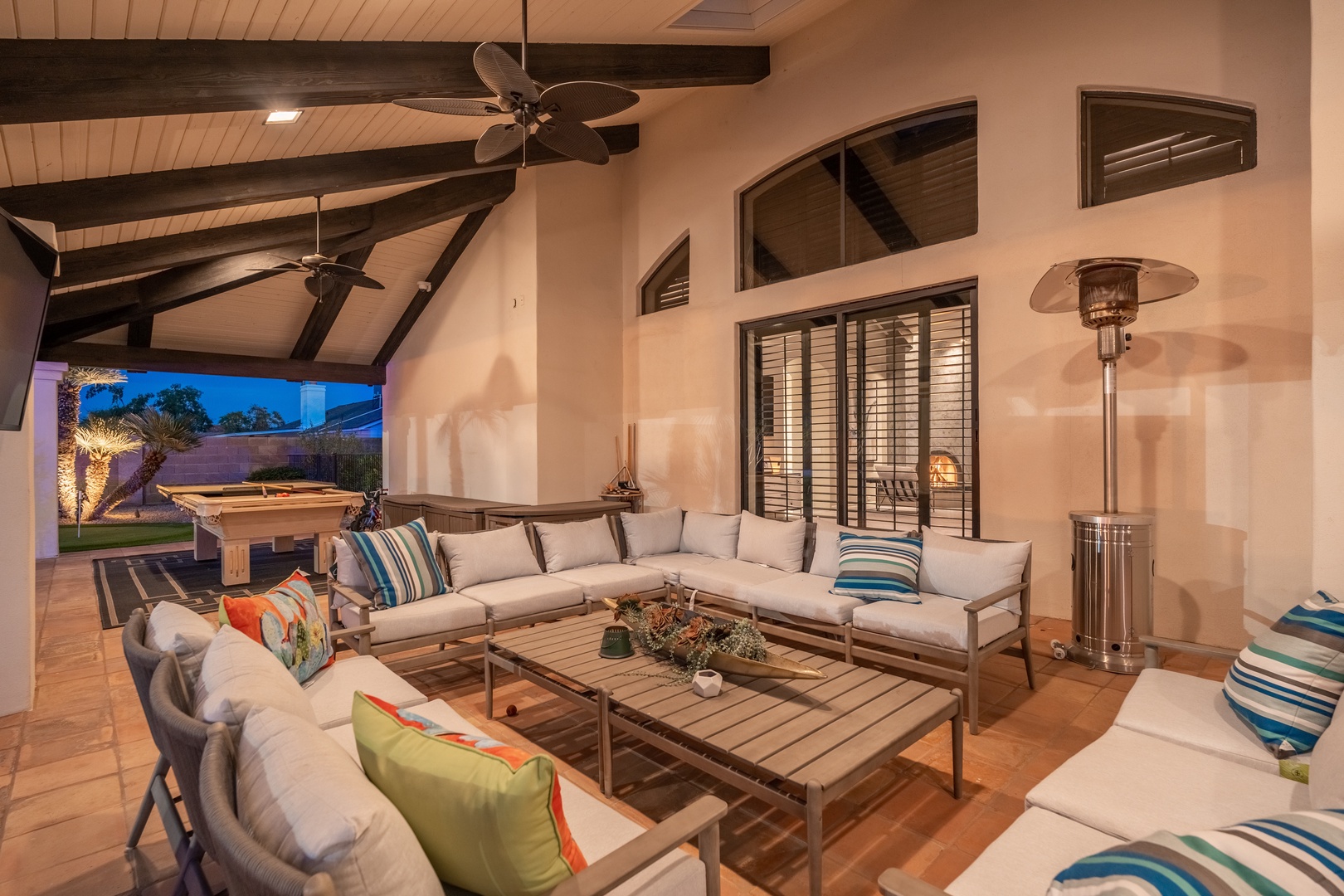 Gather your group in this expansive outdoor living area where vaulted ceilings and designer furnishings create an inviting retreat for evening conversation and games under the stars.