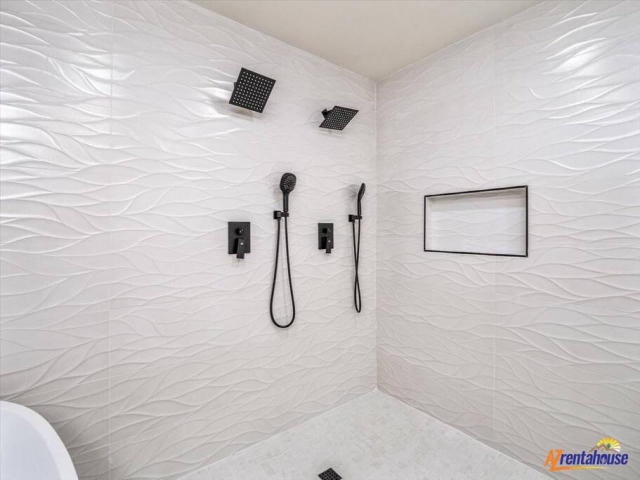 Indulge in your private spa-like shower with dual rainfall heads and handheld options, surrounded by stunning textured walls.
