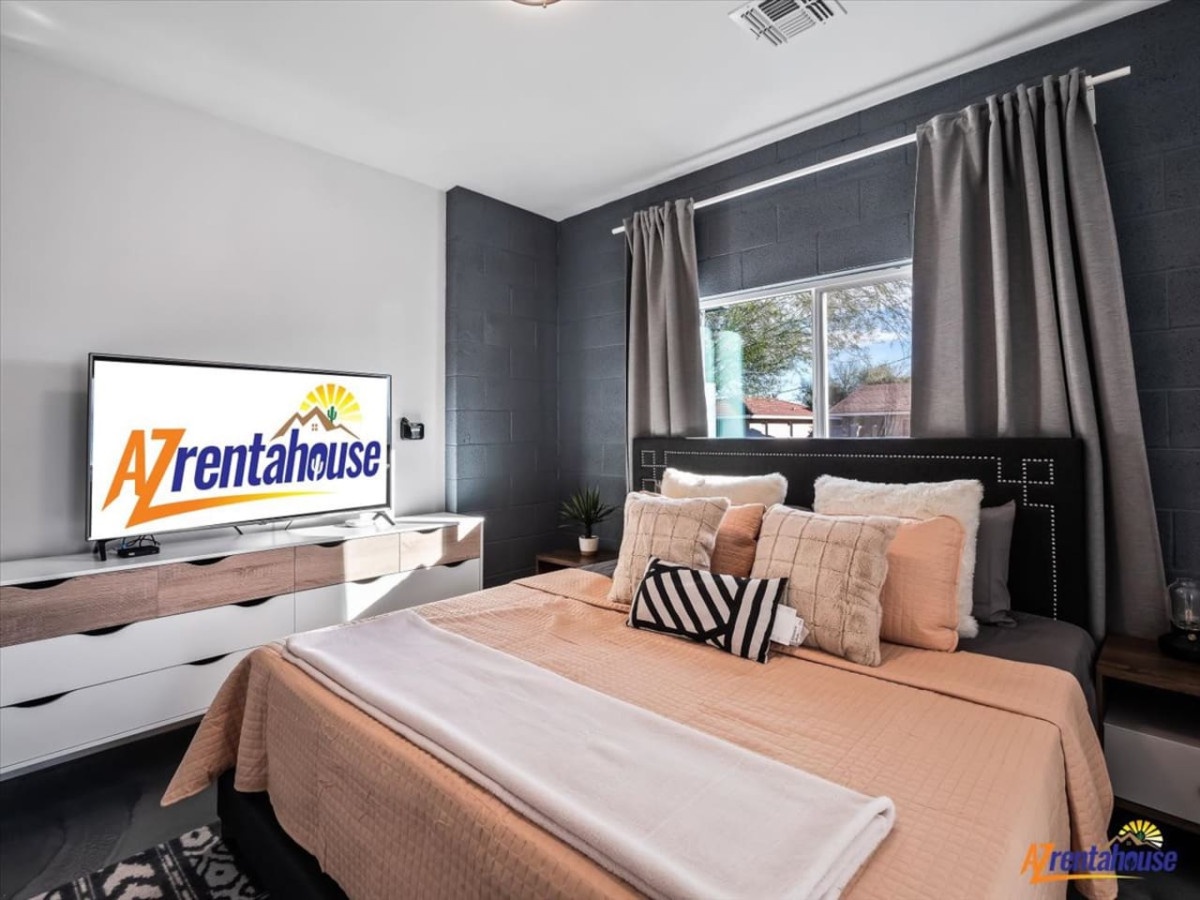 Sink into plush bedding in your modern sanctuary, where stylish décor meets comfort and a large TV awaits your evening entertainment.