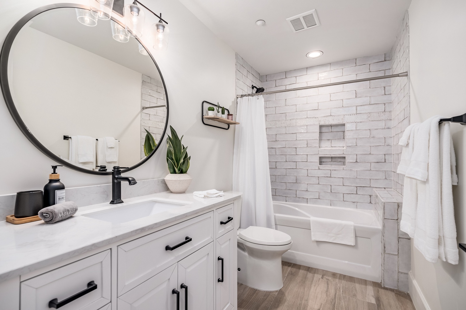 Step into your private spa-like retreat with gleaming white subway tile, a soaking tub, and modern touches that make every refresh feel luxurious.