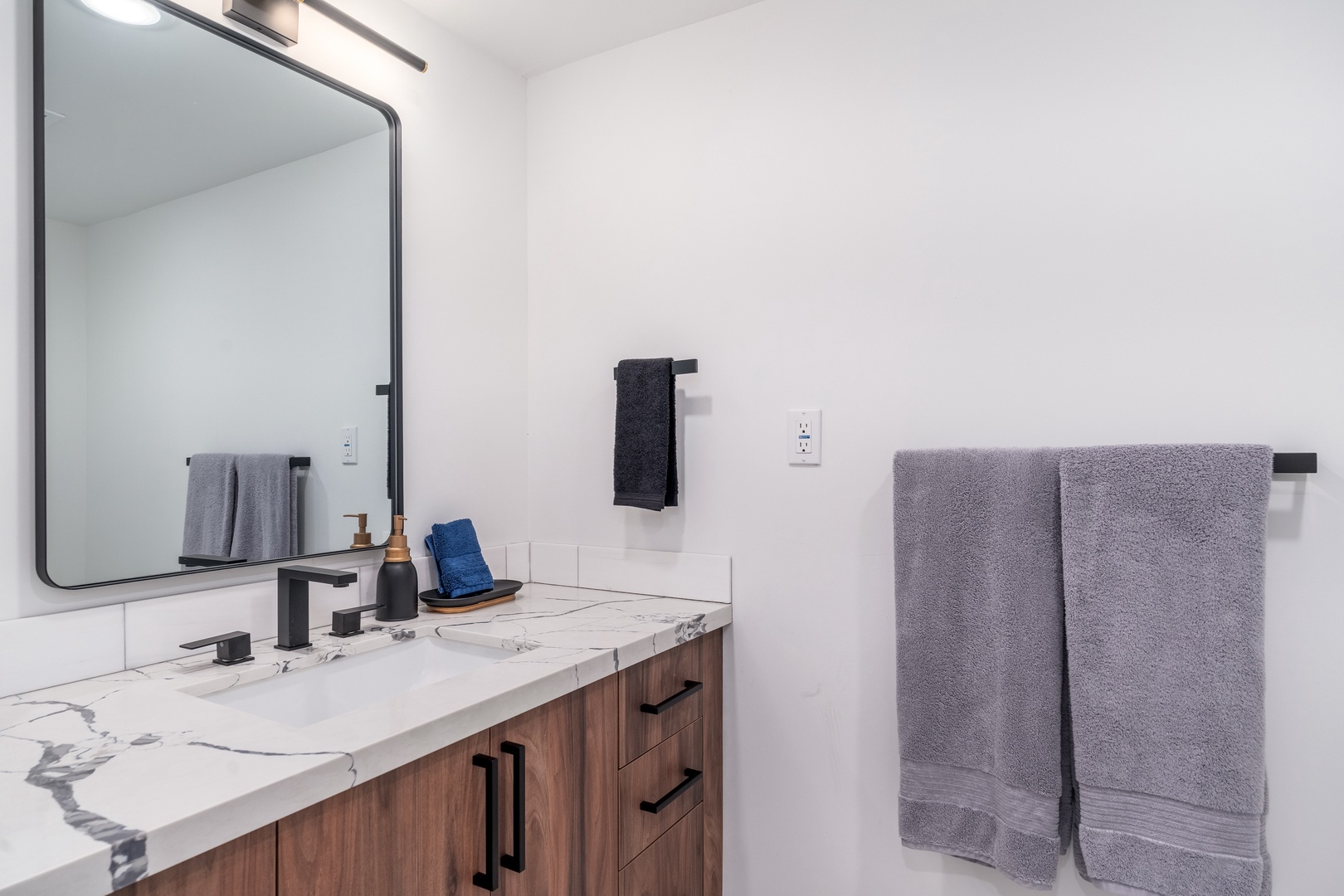 Your private bathroom features modern finishes and plush towels, with a sleek marble countertop and warm wood accents that create a spa-like retreat for your daily routine.